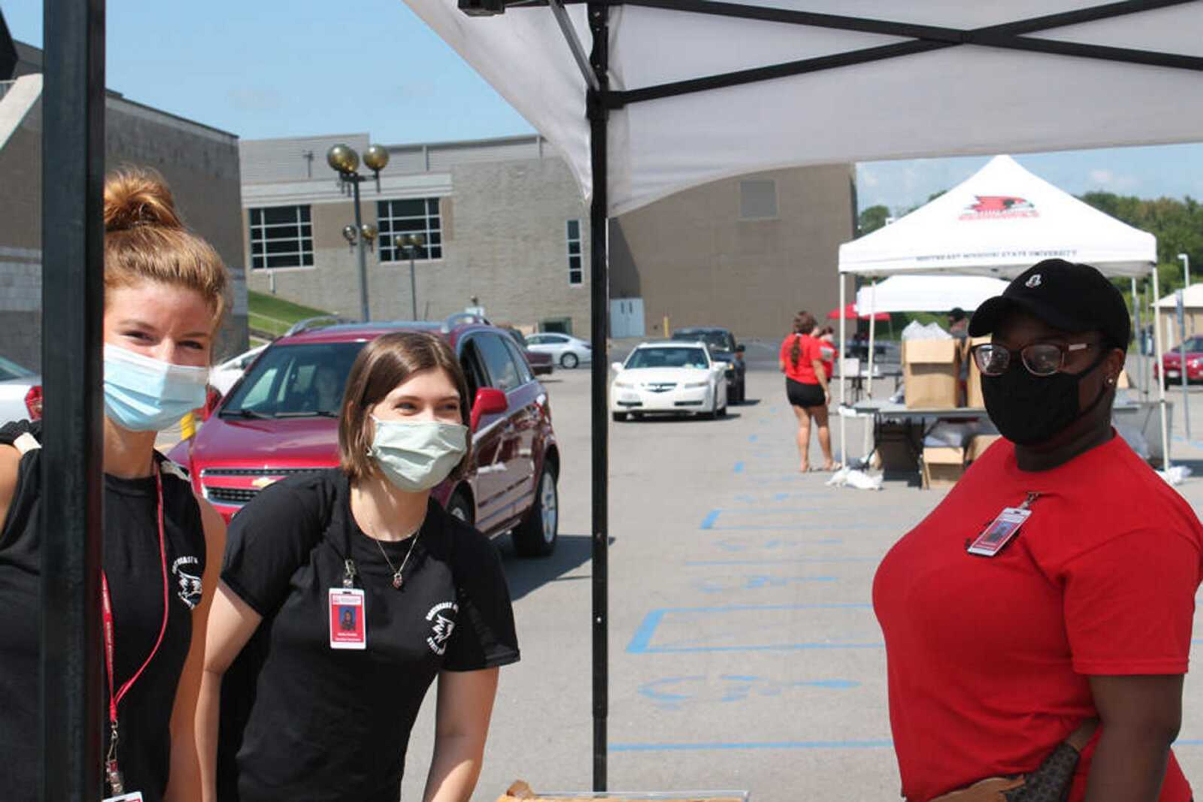 Resident assistants Ashley Moellenhoff, Hayley Huntly and Darian Forleet distribute keys on the first day of Residence Life's drive-through resident check-in Aug. 15.<br>Returning students drove from tent to tent at the Show Me Center to receive information and a health screening before receiving their keys.