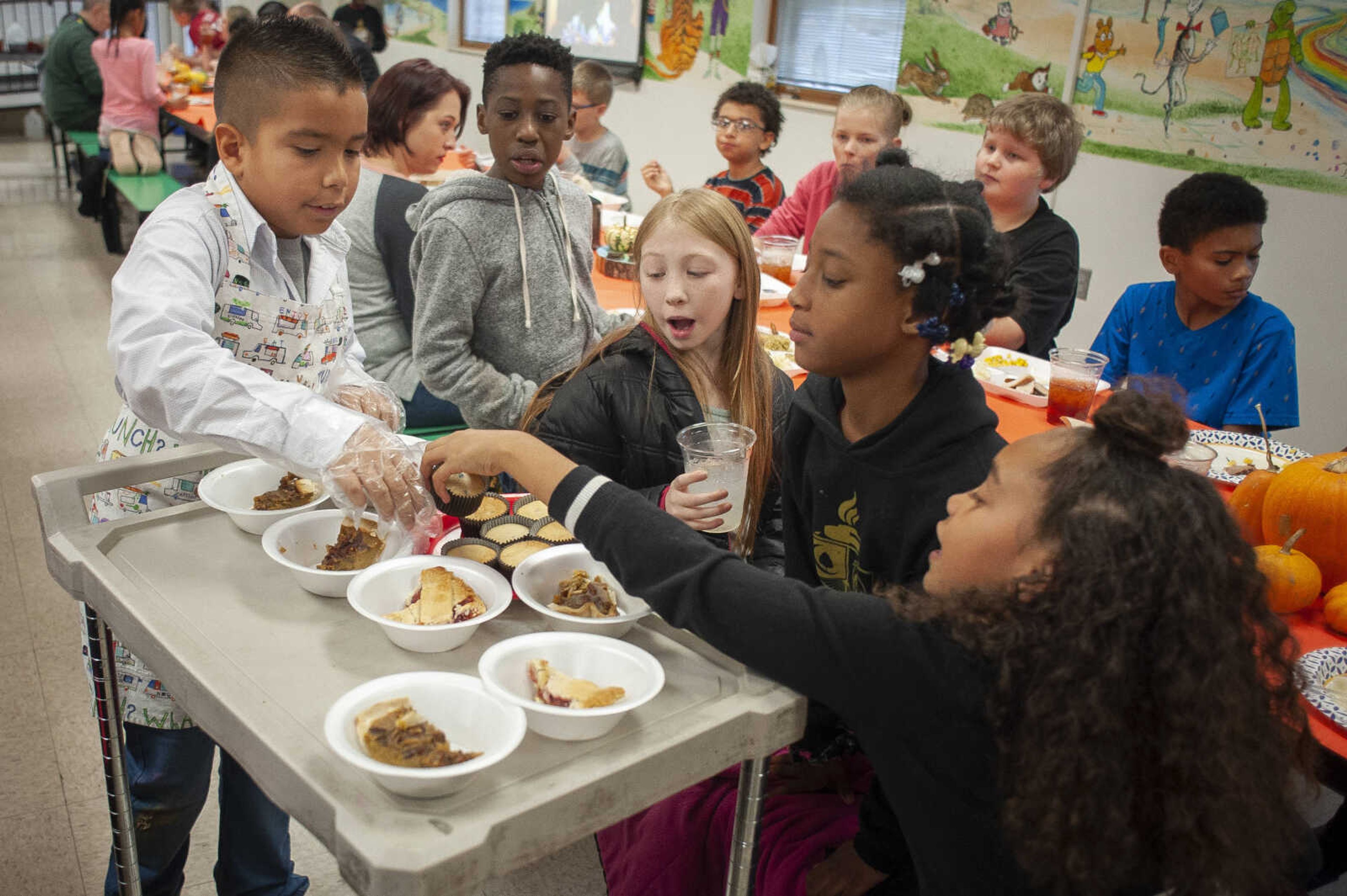 Jefferson Elementary School fourth-grader Luis Mendez handles a dessert cart as fellow fourth-graders (going right from Mendez) Jay Barnhill, Ericka Thiele, Clarissa Walker and Jiliah Geiger look at the selection during a Thanksgiving meal Tuesday, Nov. 26, 2019, at the Cape Girardeau school. Employees of Red Letter Communications sponsored the meal.