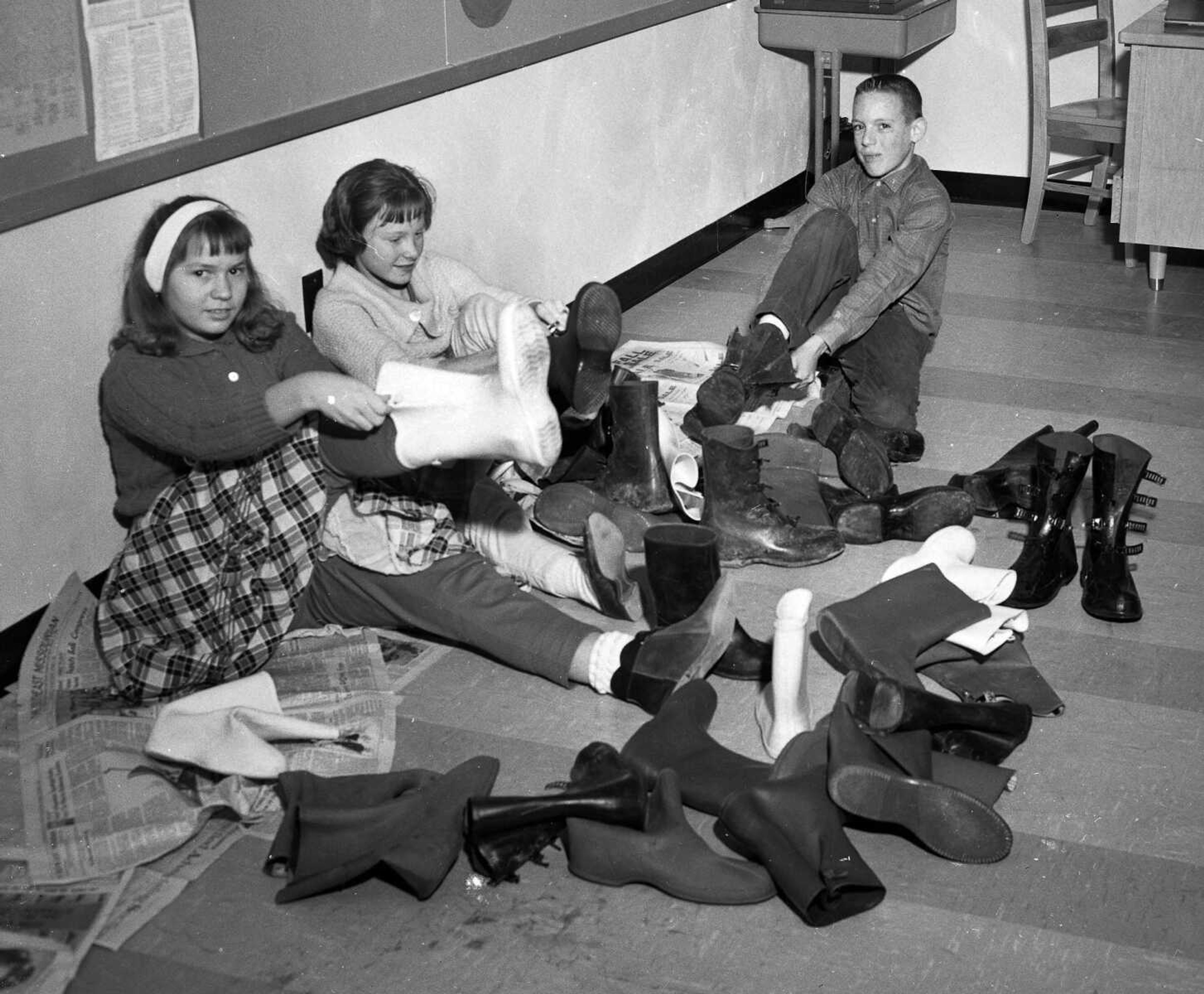 Jan. 23, 1963 Southeast Missourian.
The season’s coldest weather and snow cover brought out all kinds of inclement weather footgear. Here, three sixth-grade pupils at Alma Schrader School chose their boots from among those of classmates and don them to go home for the day. From left are Cathy Hughes, Frances Rayfield and Tom Oppenheim. (G.D. Fronabarger/Southeast Missourian archive)