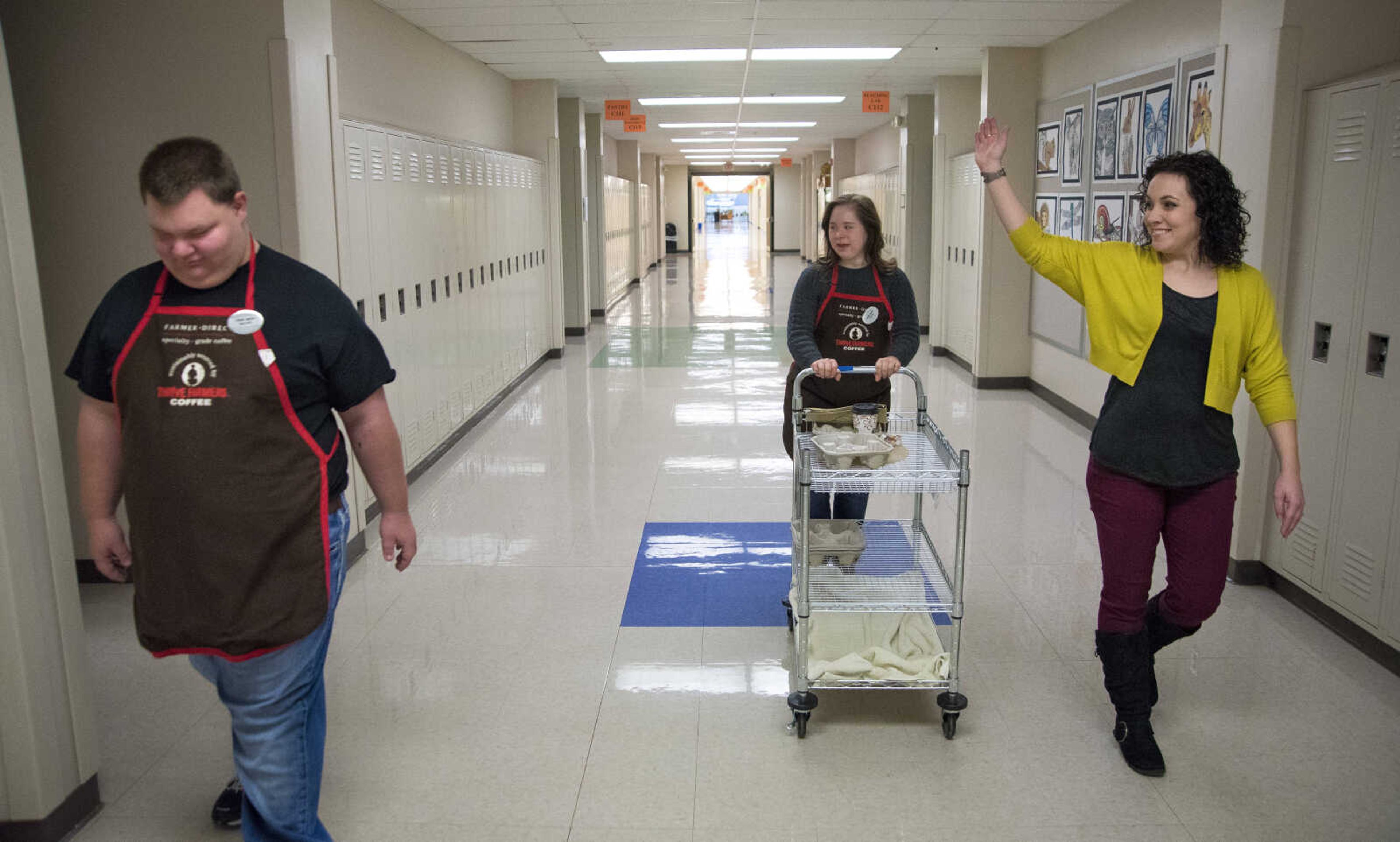 ANDREW J. WHITAKER ~ awhitaker@semissourian.com
Candice Schnurbusch, right, waves to a classroom while delivering drinks with Garrett Jones, left, and Carley House, center, for Tiger Brew, a student run business run by the special education department at Cape Girardeau Central, Tuesday, Dec. 13, 2016 in Cape Girardeau. Tiger Brew is available Monday through Friday during three different class periods, 1st hour, 2nd hour and advisory and offer a variety of drinks from hot coffees and teas, iced drinks, hot chocolates and even smoothies.