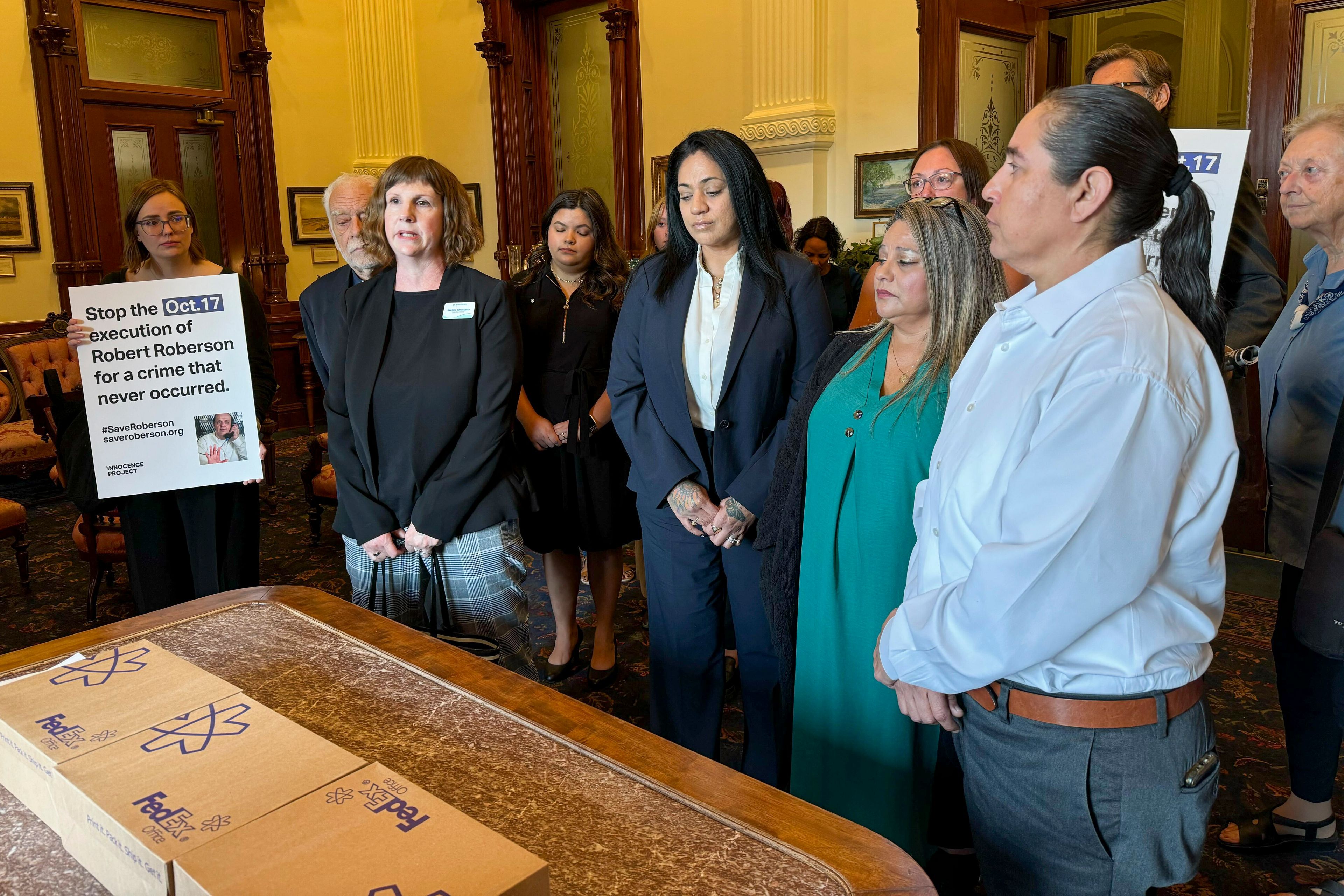 Elizabeth Ramirez, center, Casandra Rivera, center right, and Anna Vasquez, second from right, of the "San Antonio 4" group, deliver boxes with petitions in the Texas State capitol for Texas Gov. Greg Abbott seeking the pardoning of Robert Roberson's execution, Wednesday, Oct. 16, 2024, in Austin, Texas. Roberson, 57, is scheduled to receive a lethal injection on Oct. 17, for the 2002 killing of his 2-year-old daughter, Nikki Curtis, in the East Texas city of Palestine. Roberson has long proclaimed his innocence. (AP Photo/Nadia Lathan)