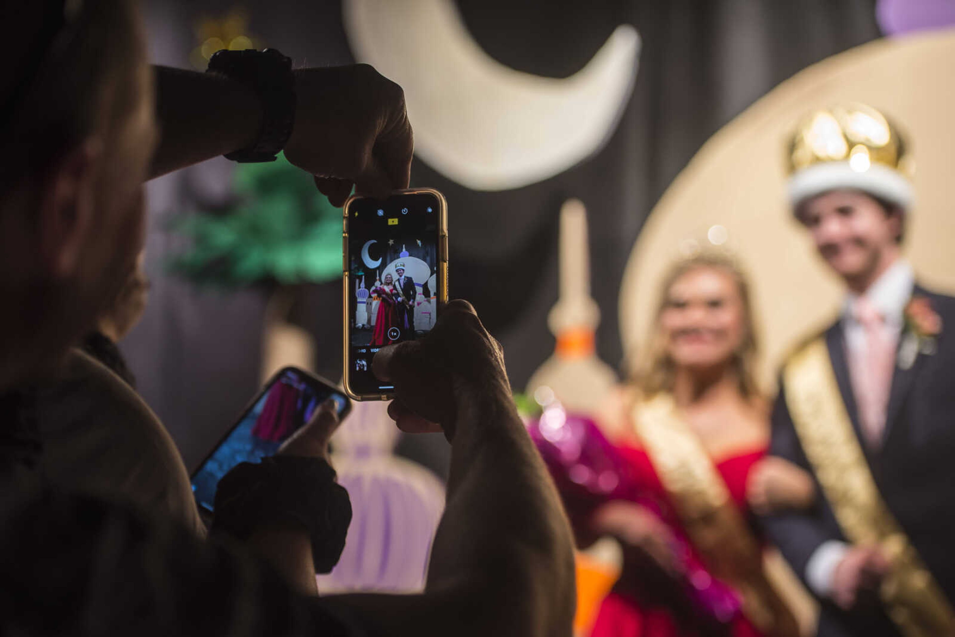 Chris Lambert, father of Prom Queen Lauren Lambert, takes photos with his phone of his daughter and Prom King Tyler Wolf during prom Saturday, April 6, 2019, at Kelly High School in Benton.