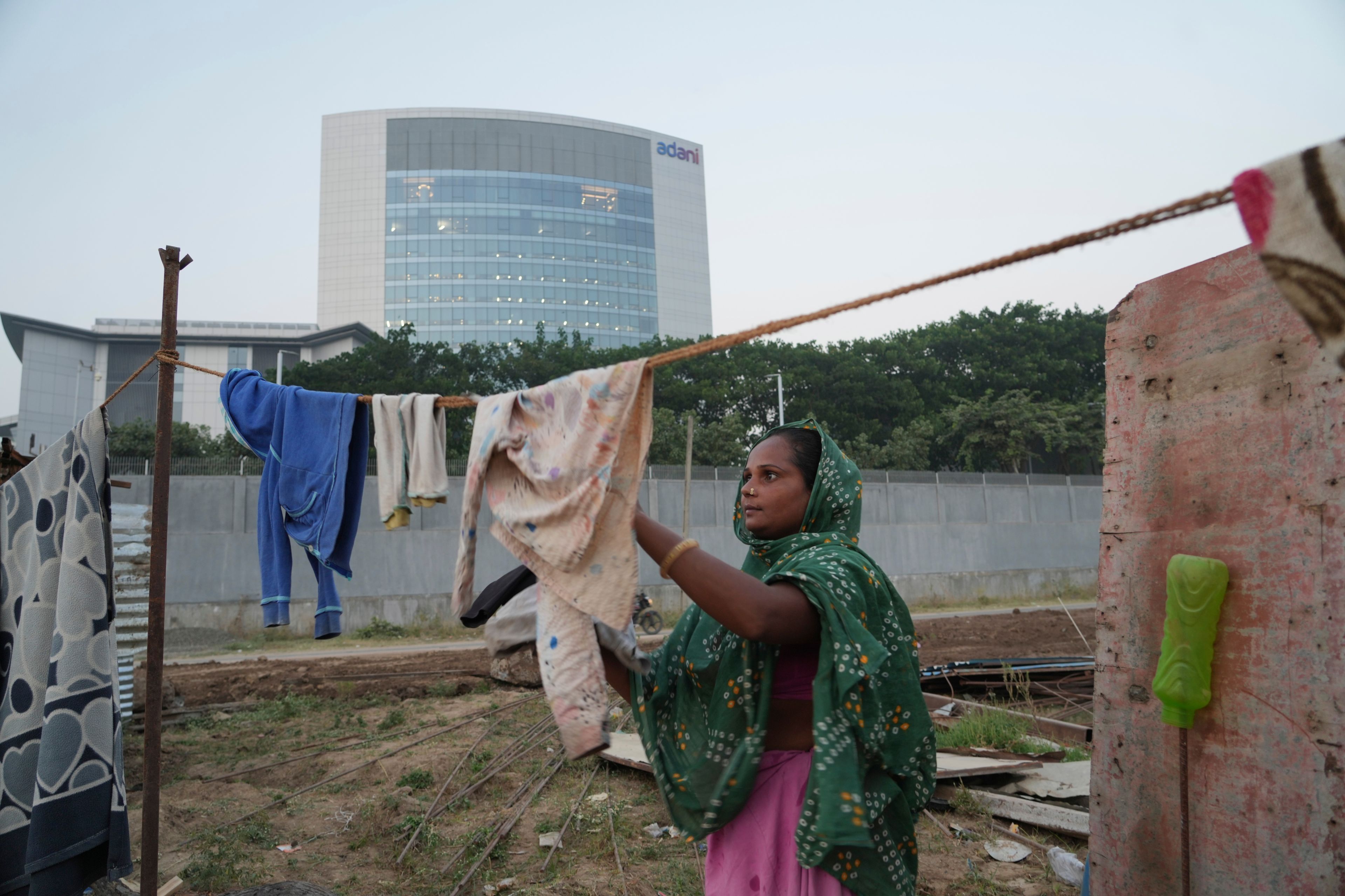 A woman dries clothes near Adani Corporate House in Ahmedabad, India, Friday, Nov. 22, 2024. (AP Photo/Ajit Solanki)