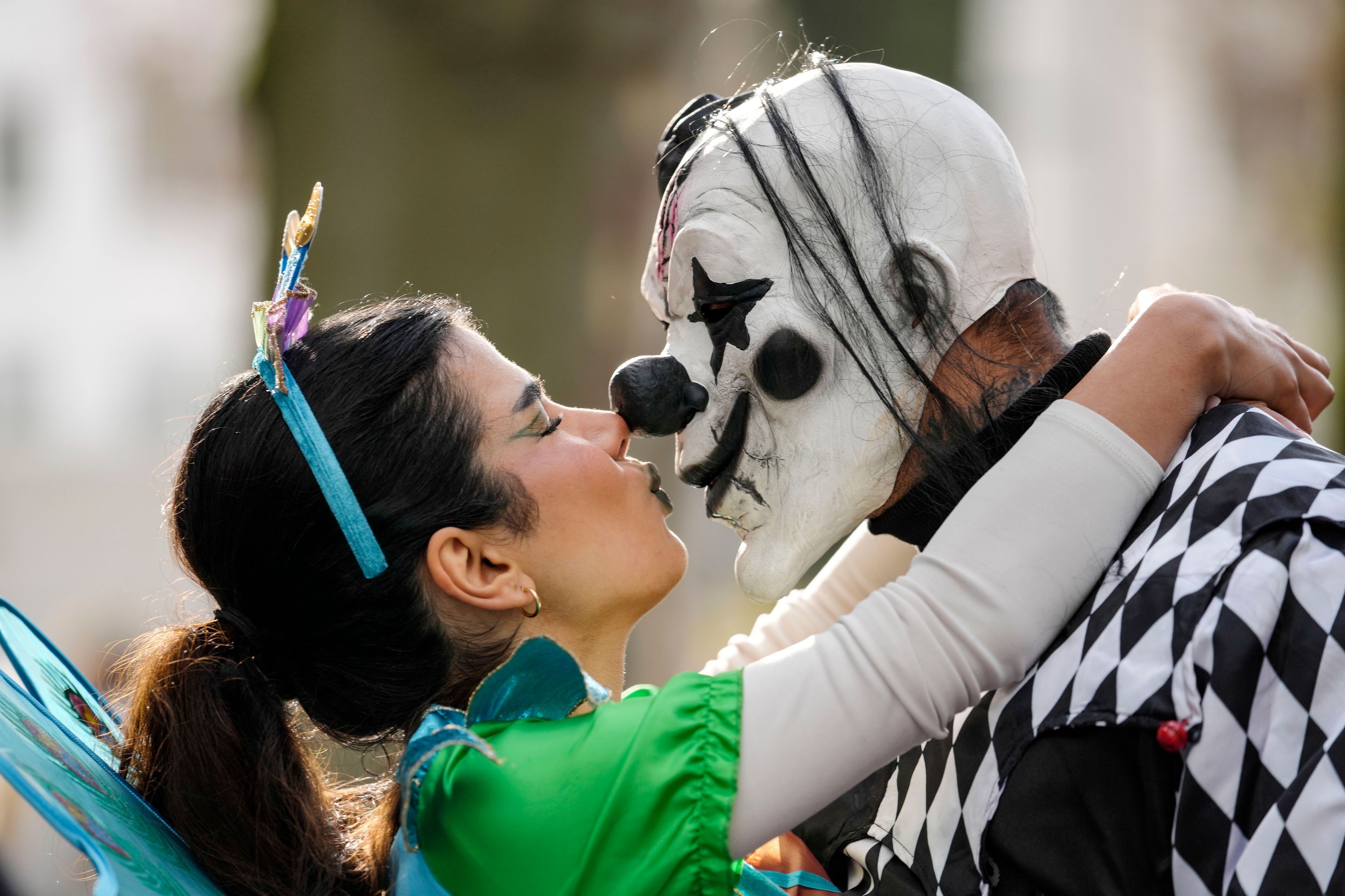 Revelers dressed in costumes kiss at the Zuelpicher Street while tens of thousands of carnival fools take to the streets of Cologne, Germany, on Monday, Nov. 11, 2024, heralding the official start of the carnival season. (AP Photo/Martin Meissner)