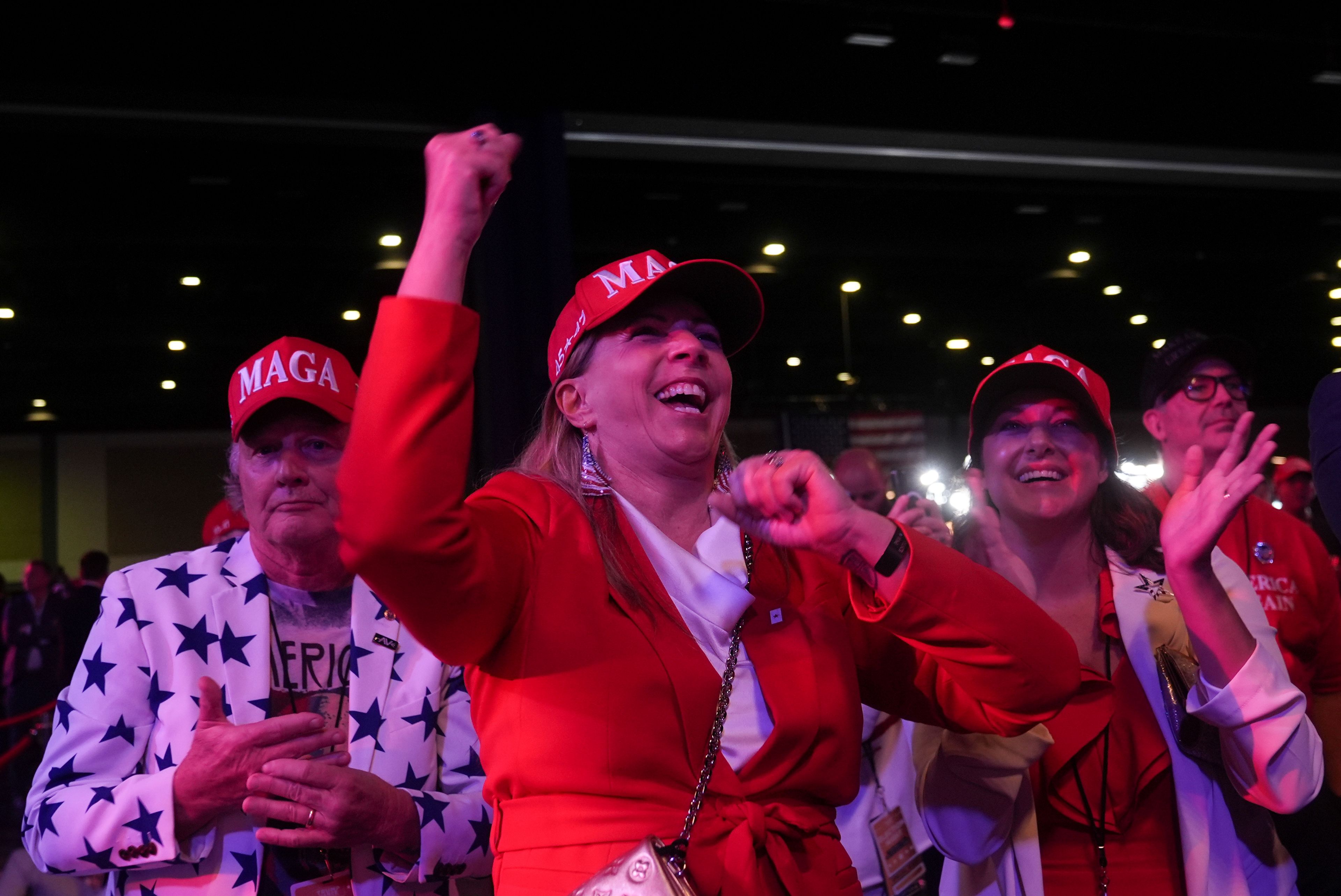 Karen Vaughn, center, reacts with her husband Billy, left, and daughter Anna as they watch election results at an election night campaign watch party for Republican presidential nominee former President Donald Trump, Wednesday, Nov. 6, 2024, in West Palm Beach, Fla. (AP Photo/Marta Lavandier)