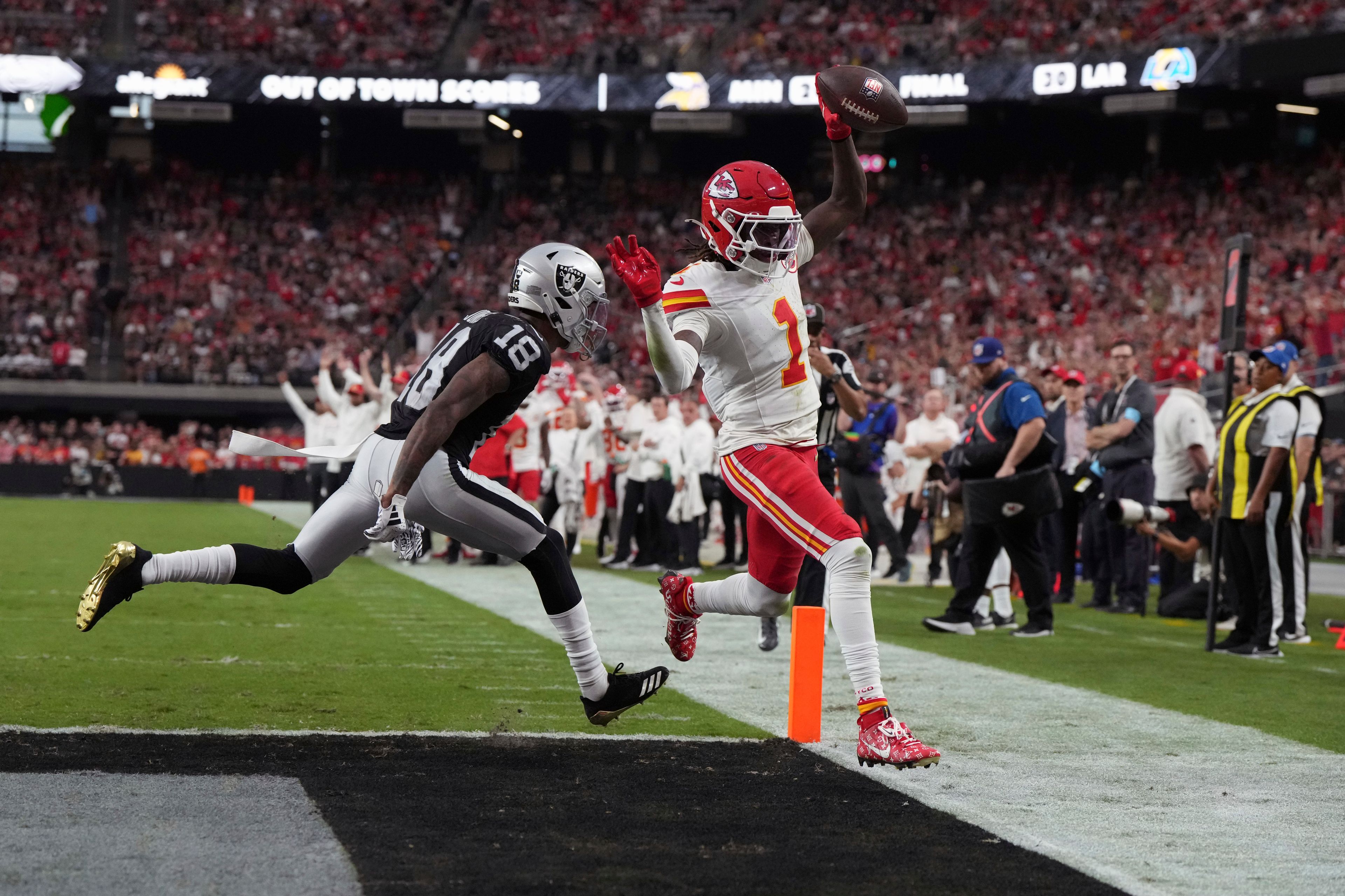 Kansas City Chiefs wide receiver Xavier Worthy (1) scores past Las Vegas Raiders cornerback Jack Jones (18) during the second half of an NFL football game Sunday, Oct. 27, 2024, in Las Vegas. (AP Photo/Rick Scuteri)