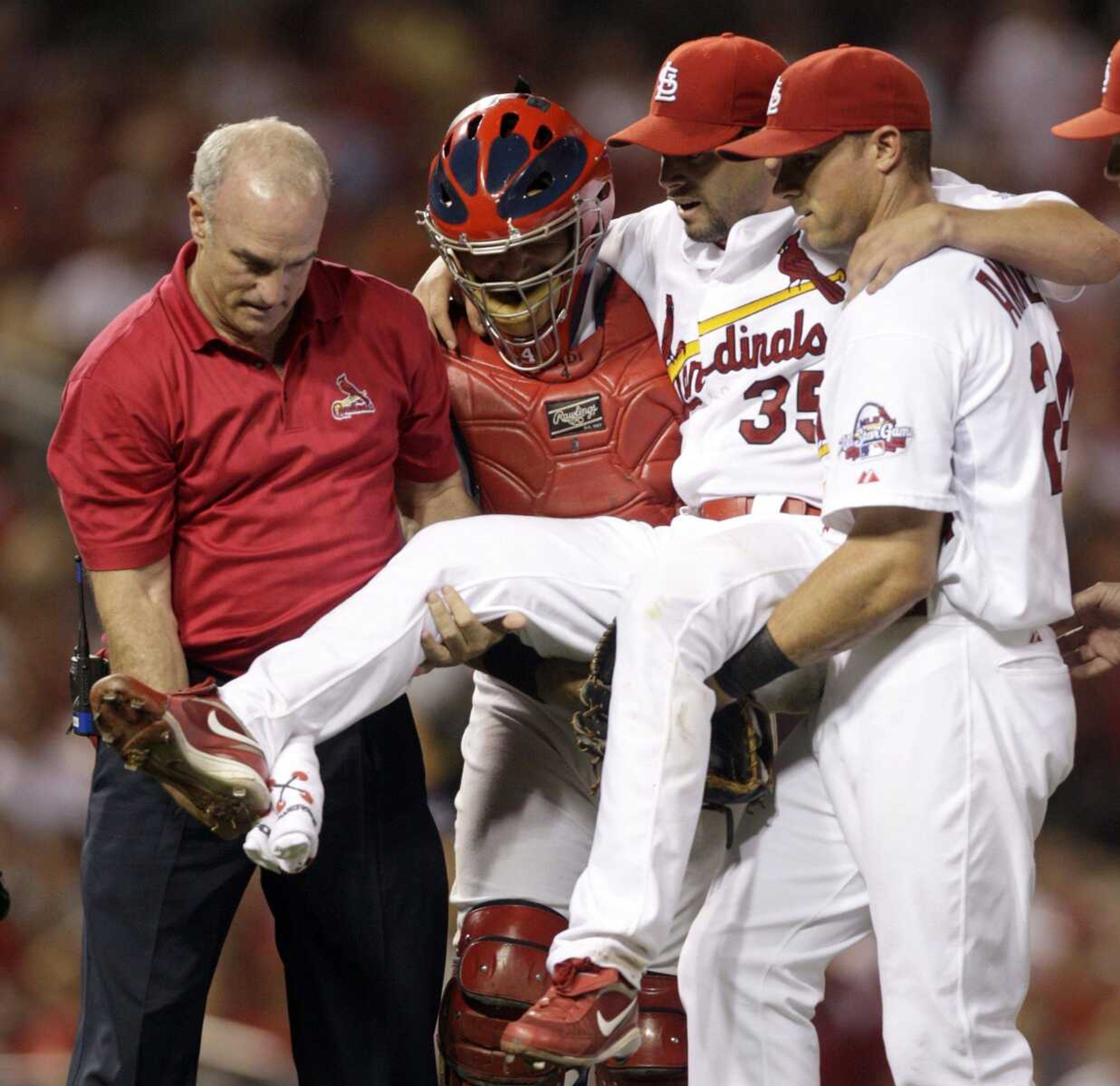 Cardinals starting pitcher Joel Pineiro is carried off the field by teammates Rick Ankiel, right, catcher Yadier Molina and trainer Barry Weinberg after striking out the Tigers' Josh Anderson to end the top of the seventh inning. Pineiro was suffering from leg cramps. (JEFF ROBERSON ~ Associated Press)