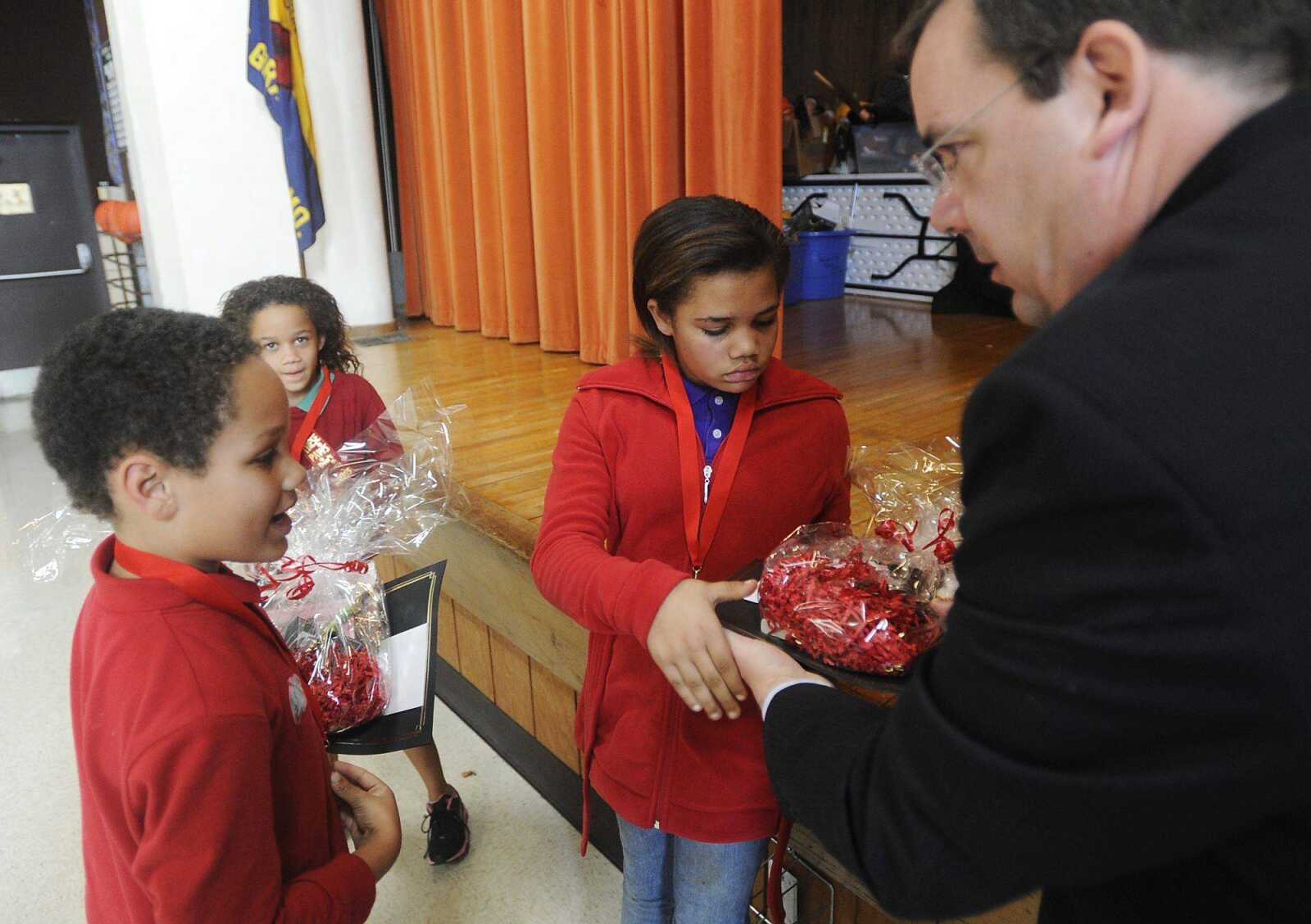 Jeffery Turk holds his award while sisters Lizzie, left, and Kayleigh receive theirs from James Stapleton, director of Southeast Missouri State University&#8217;s Center for Innovation and Entrepreneurship, during an awards ceremony Tuesday at Jefferson Elementary. (ADAM VOGLER)