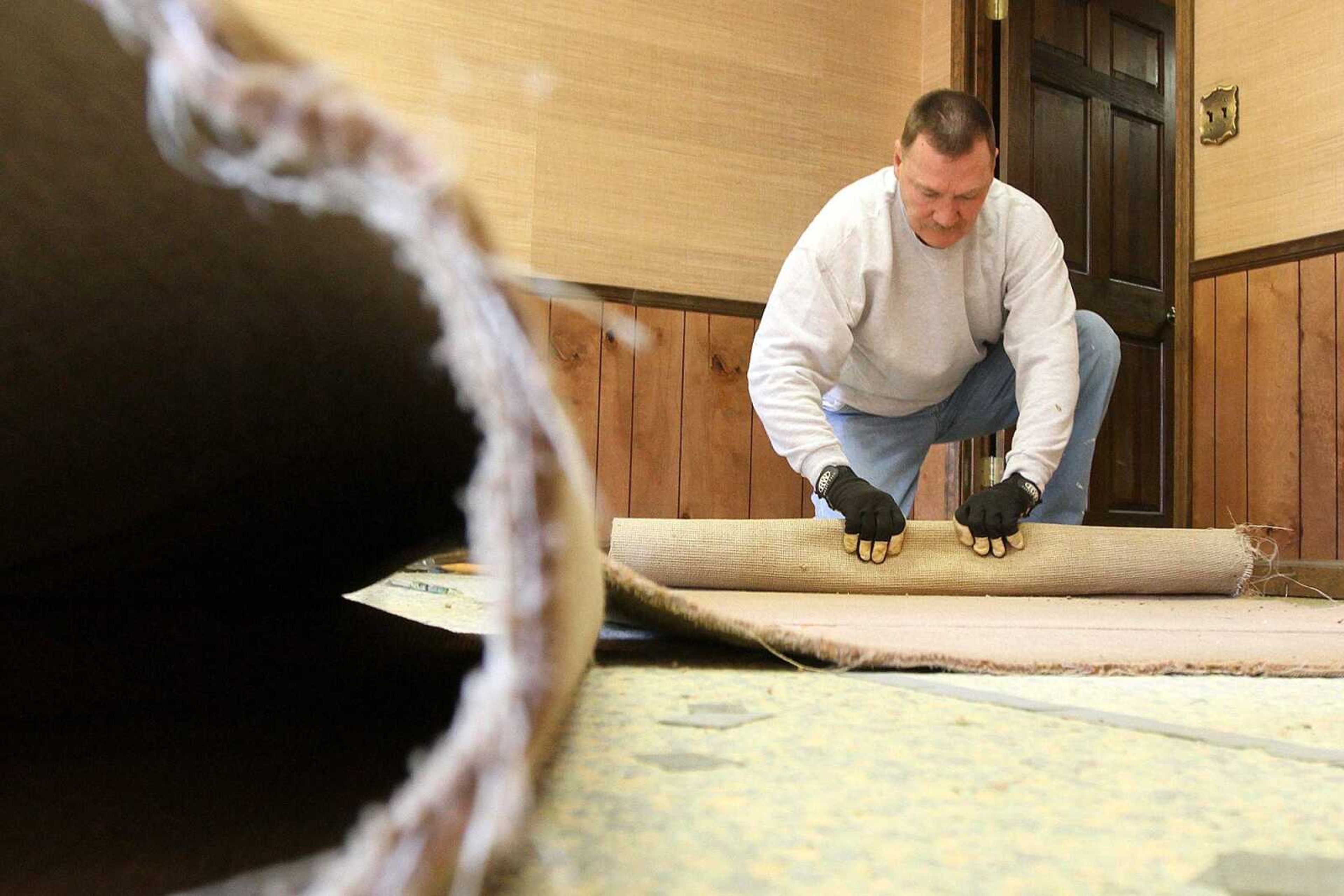 Dale Ferguson, a Scott City Chamber of Commerce member, rolls up carpet during renovations Dec. 12 at the new location of the chamber offices. (Glenn Landberg)