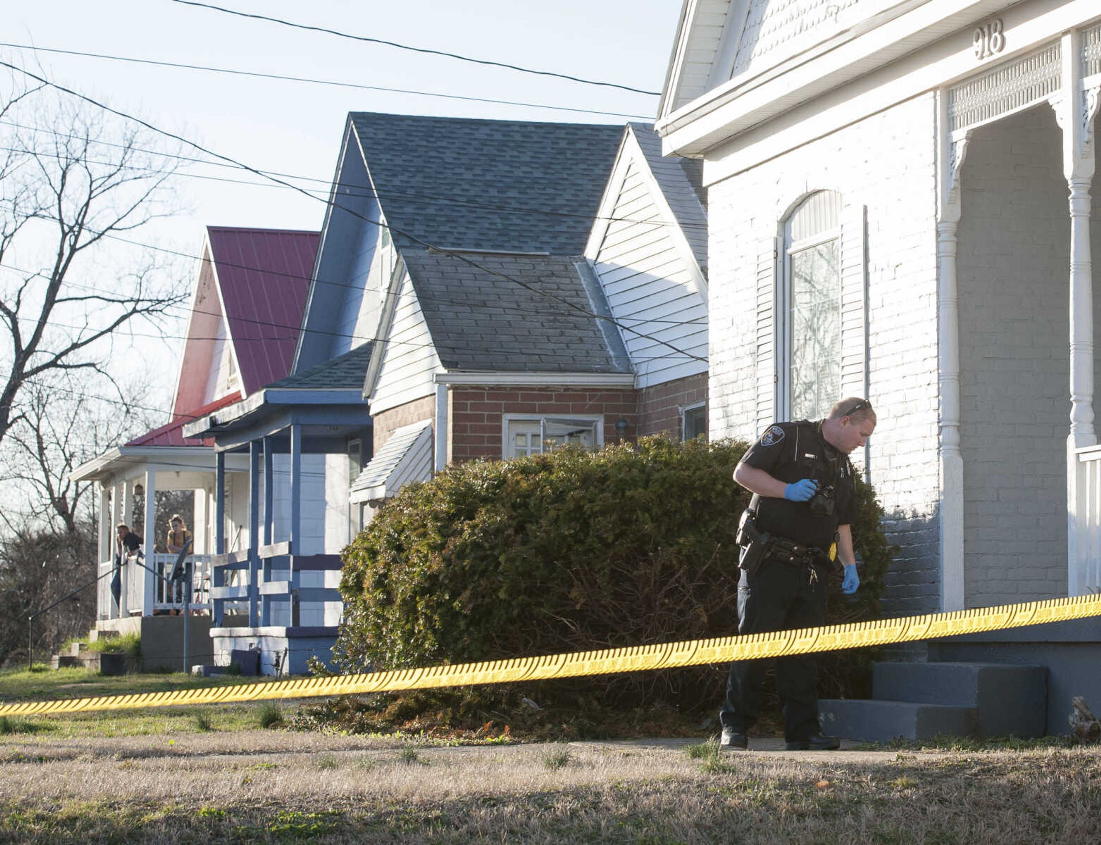 Neighbors watch as Cape Girardeau police officers investigate the scene of a shooting at 918 College Street on Tuesday, March 3, 2020, in Cape Girardeau.