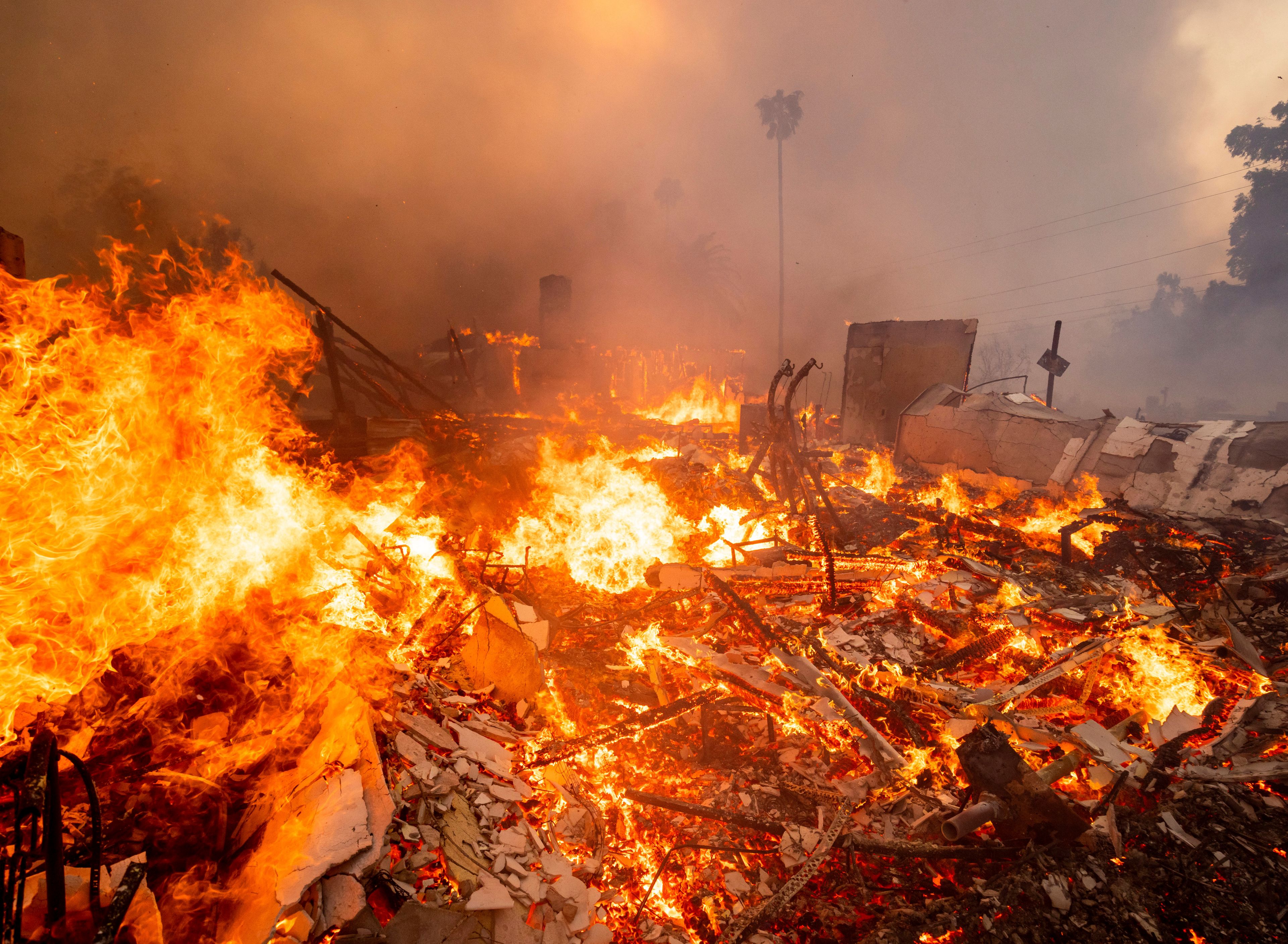 Thousands ordered to evacuate as powerful wind-fed wildfire burns homes in Southern California