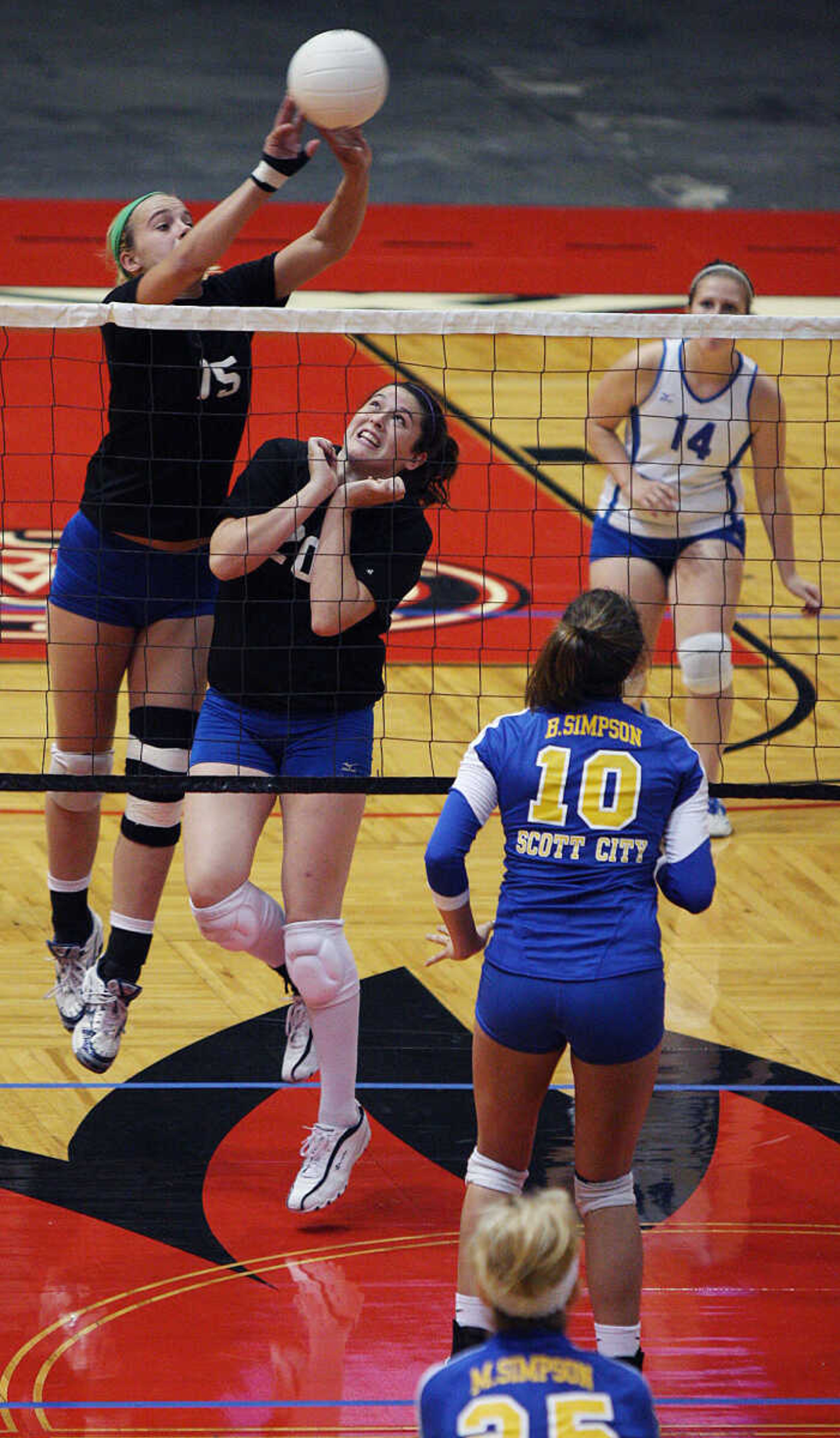 Seckman's Emily Coon, left, leaps over teammate to return the ball against Scott City.