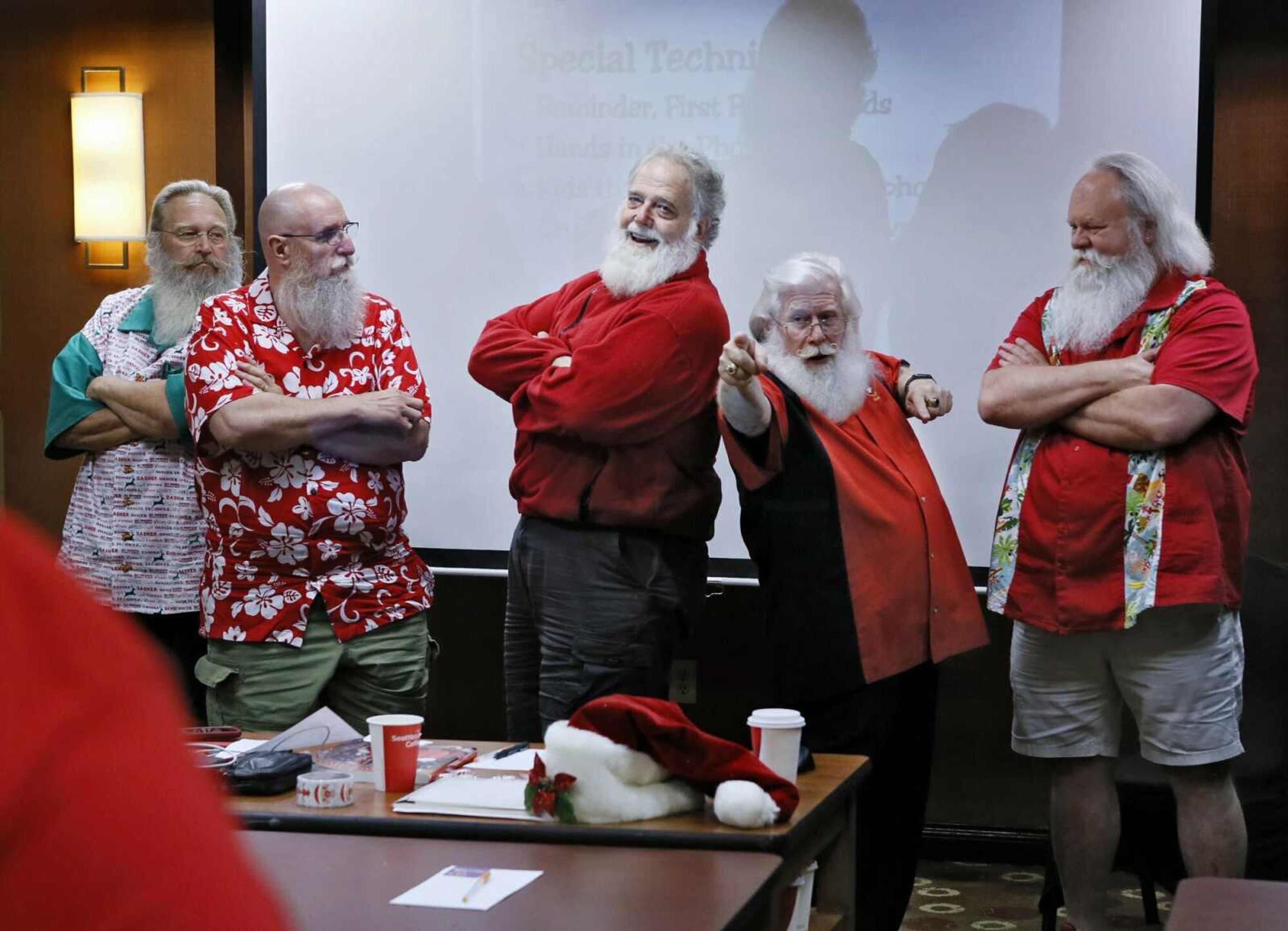 In a June 22 photo, Tim Connaghan, second from right, teaches Mike Smith of Columbus, Randall Reed of Canton, Bob Roumeliote of Columbus, and Frank Chappell, right, of St. Peters, Mo., some ways to get men to pose with Santa during the School4Santa at the Hyatt Place in Dublin,Ohio.