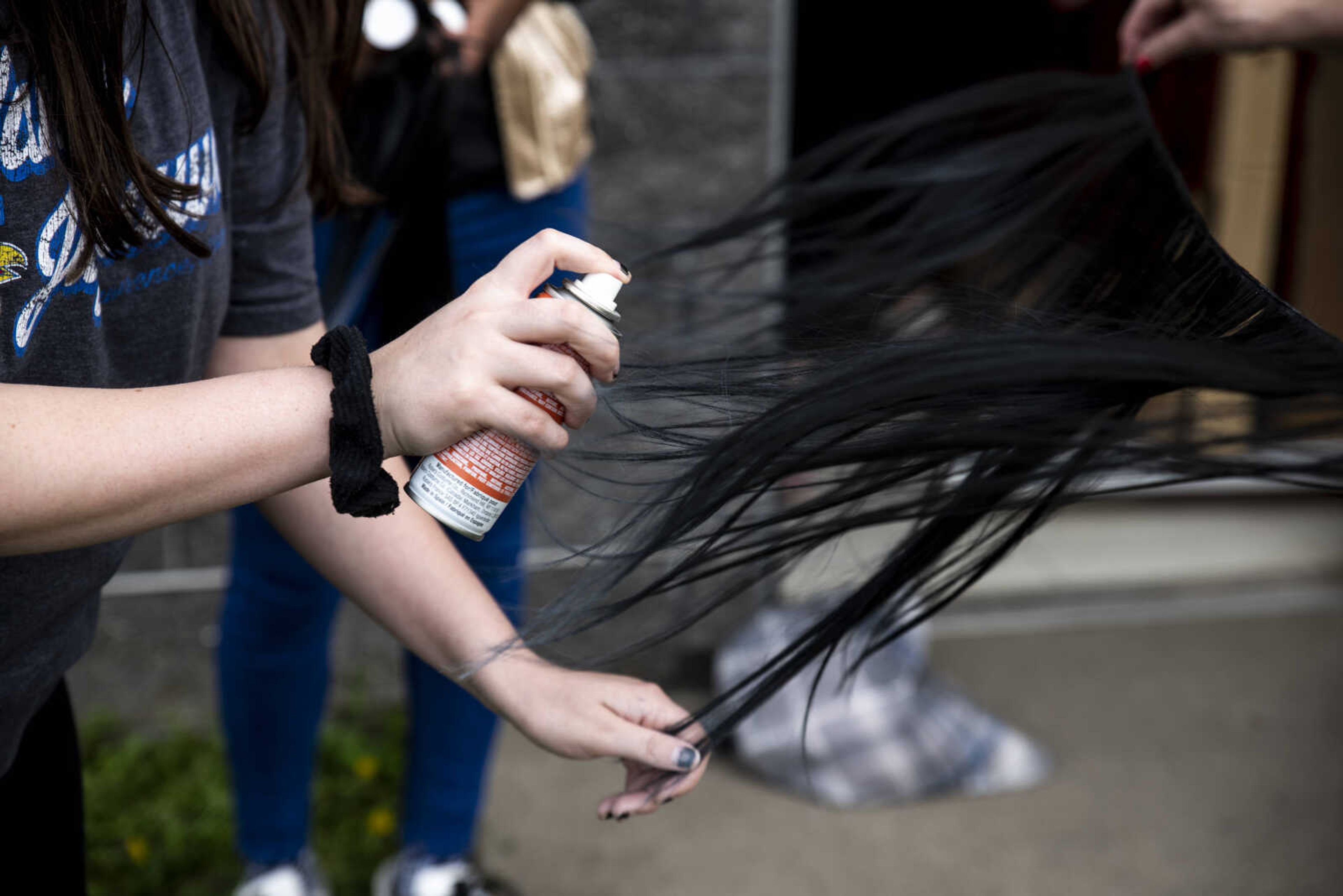 Elizabeth Hughes, makeup head, left, sprays hair extensions with grey for the costume of Peighton Robinson who is playing Donna Robinson for Cape Central High School's spring musical production of "Mamma Mia!" Wednesday, April 10, 2019, in Cape Girardeau.