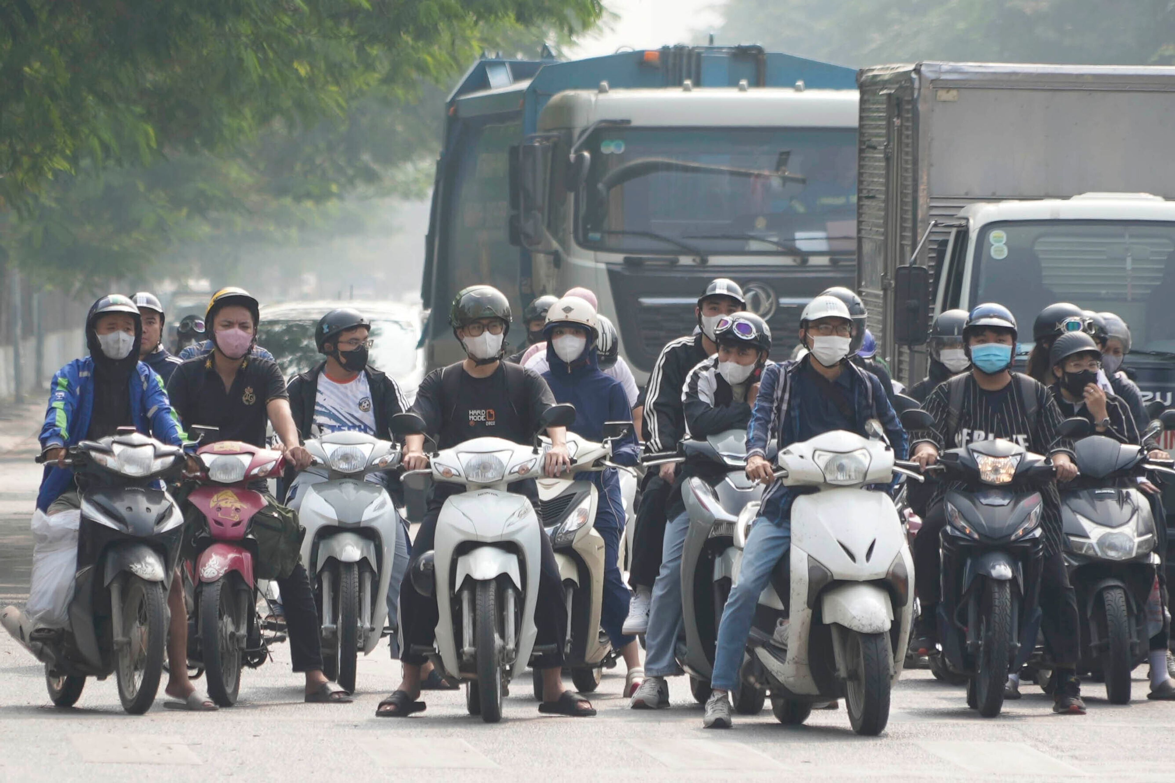 People wearing face masks wait at a traffic signal in Hanoi, Vietnam, Thursday Nov. 14, 2024. (AP Photo/Hau Dinh)