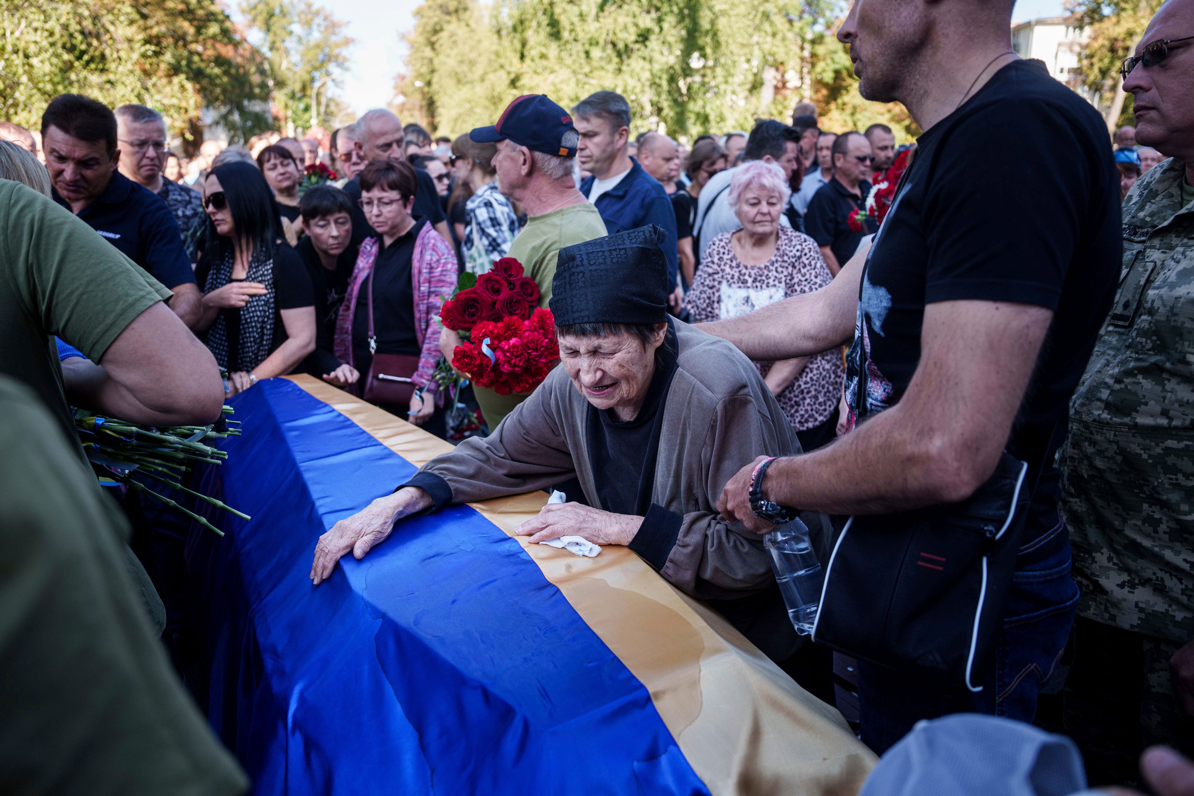 A mother cries near the coffin of her son killed in a Russian rocket attack at a Ukrainian military academy, during his funeral ceremony in Poltava, Ukraine, Saturday Sept. 7, 2024. (AP Photo/Evgeniy Maloletka)