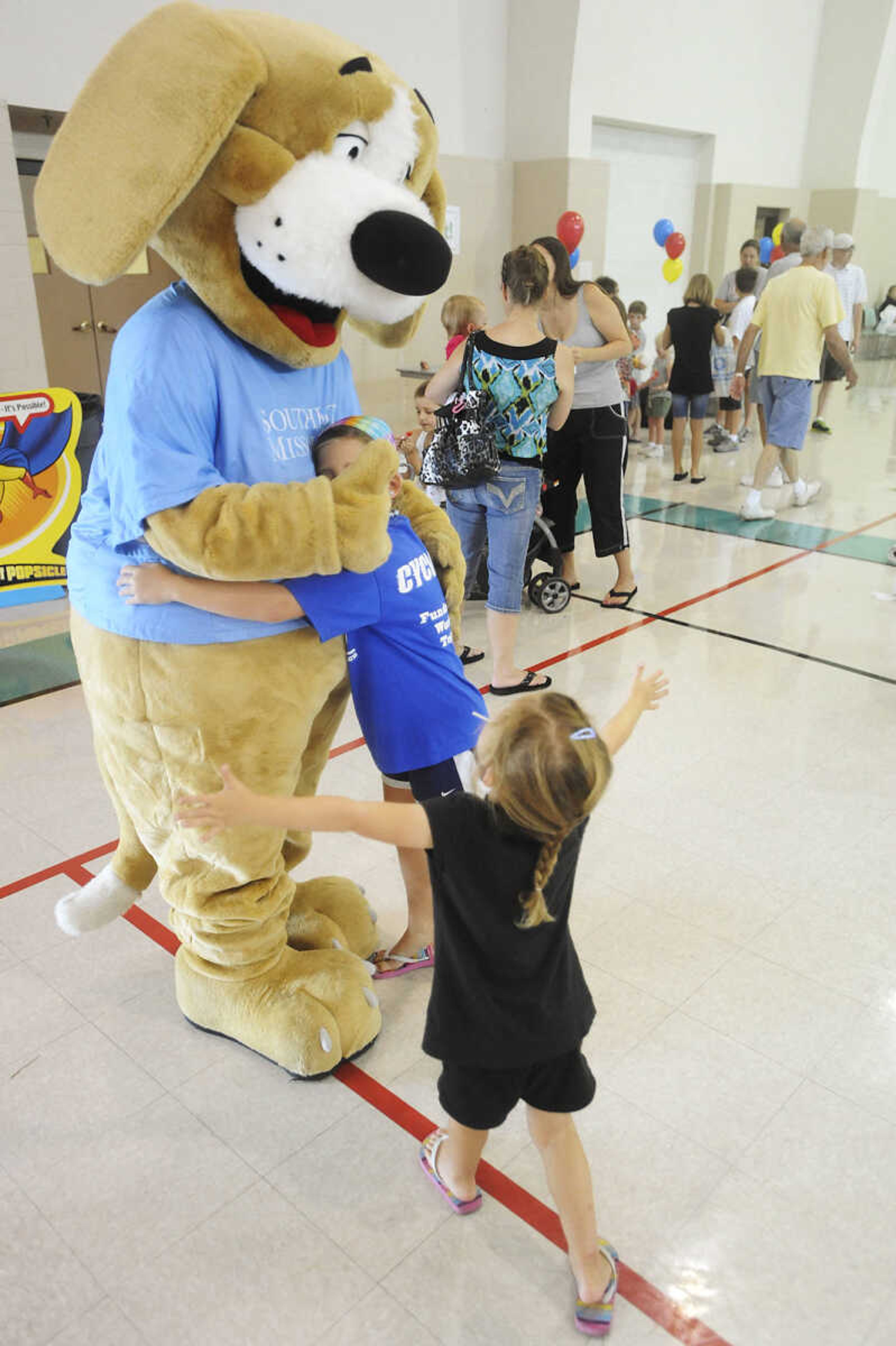 ADAM VOGLER ~ avogler@semissourian.com
Maddie, right, 4, and Abbey, 8, Klund surround Tracker wanting hugs during the 11th annual Cape Girardeau Parks and Rec Day Friday, July 13, at the Osage Center.