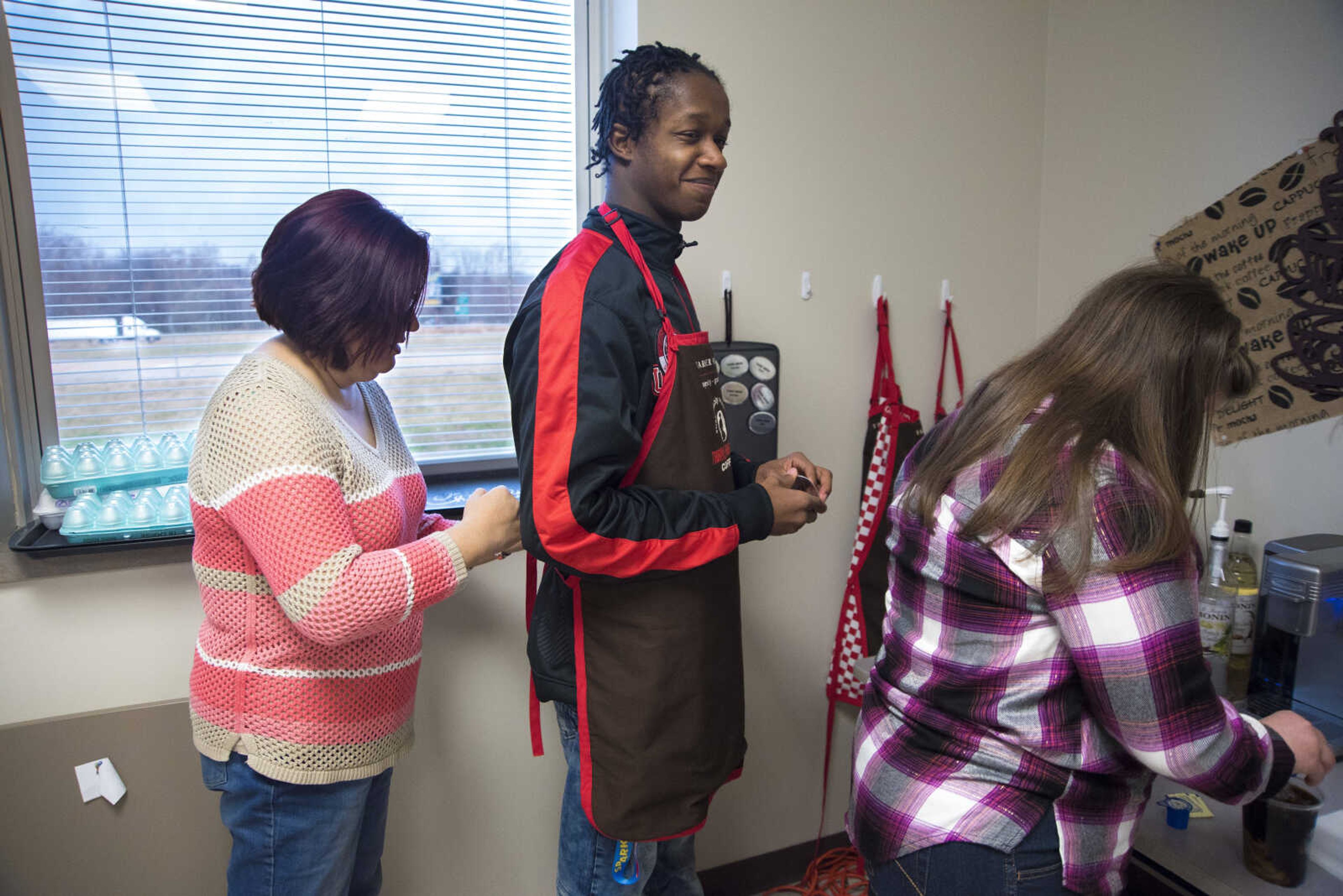 ANDREW J. WHITAKER ~ awhitaker@semissourian.com
Stacy Klusmeier, left, helps Tevontay Hulbert with his apron while Cori Brennecke makes a drink for Tiger Brew, a student run business run by the special education department at Cape Girardeau Central, Tuesday, Dec. 13, 2016 in Cape Girardeau. Tiger Brew is available Monday through Friday during three different class periods, 1st hour, 2nd hour and advisory and offer a variety of drinks from hot coffees and teas, iced drinks, hot chocolates and even smoothies.