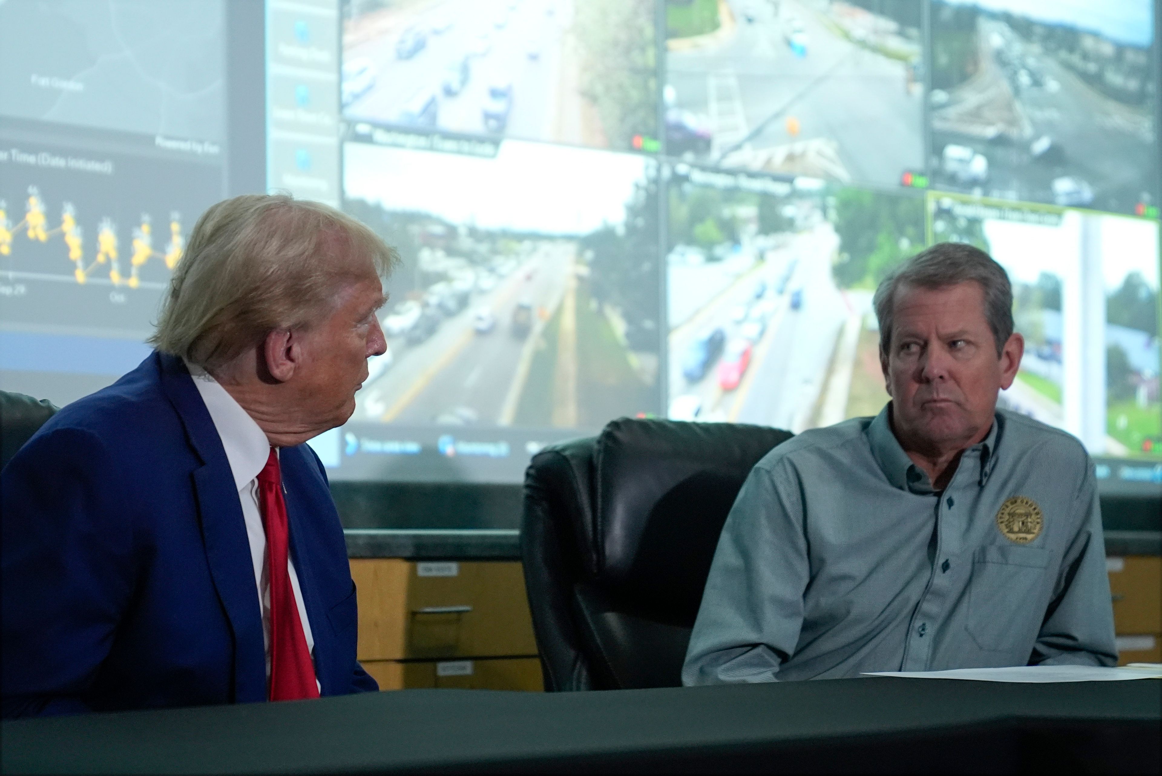 Republican presidential nominee former President Donald Trump talks with Georgia Gov. Brian Kemp during a briefing at the Columbia County Emergency Management Agency as he visits areas impacted by Hurricane Helene, Friday, Oct. 4, 2024, in Evans, Ga. (AP Photo/Evan Vucci)