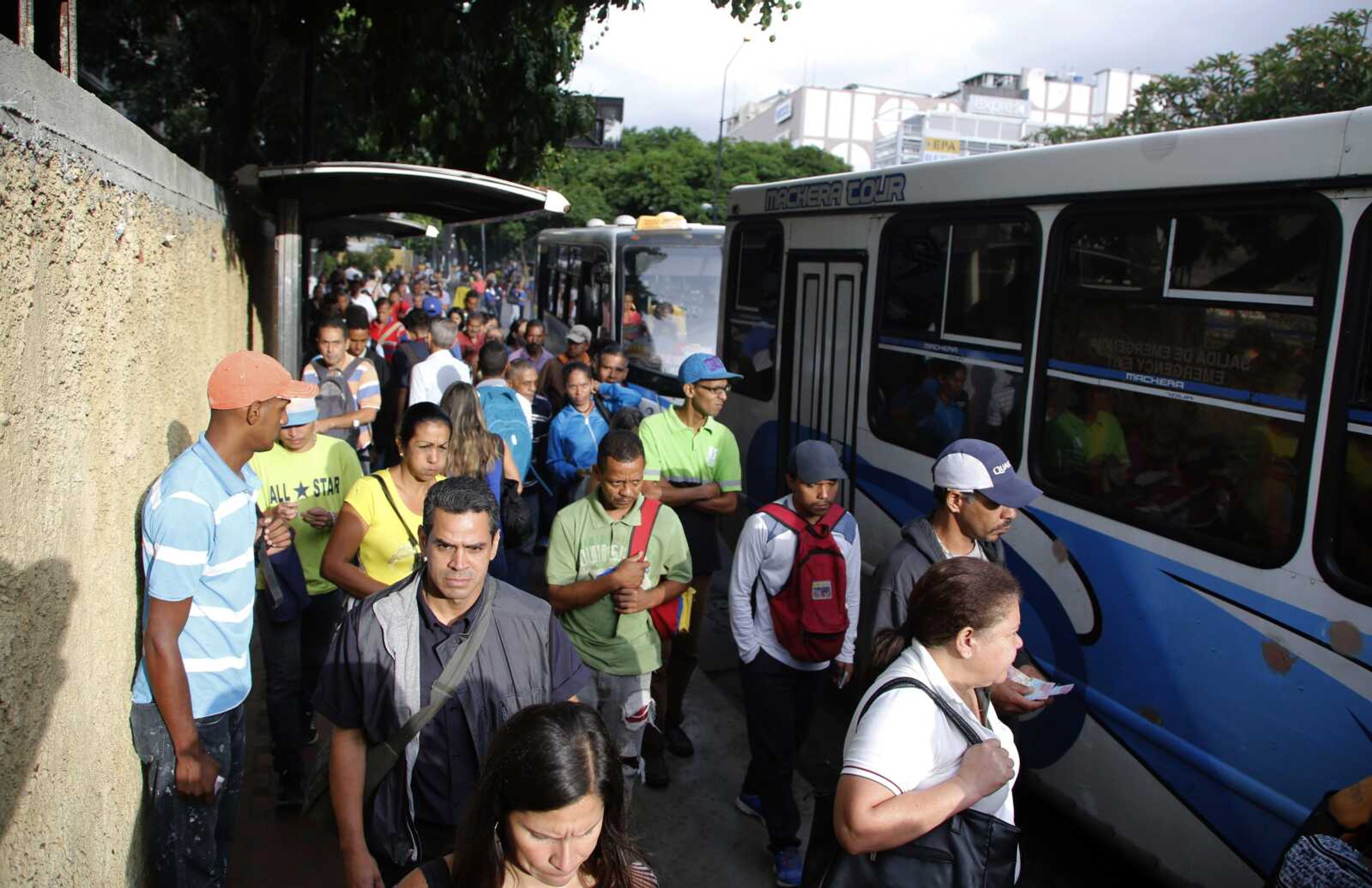 People stand in a bus line Tuesday in Caracas, Venezuela.