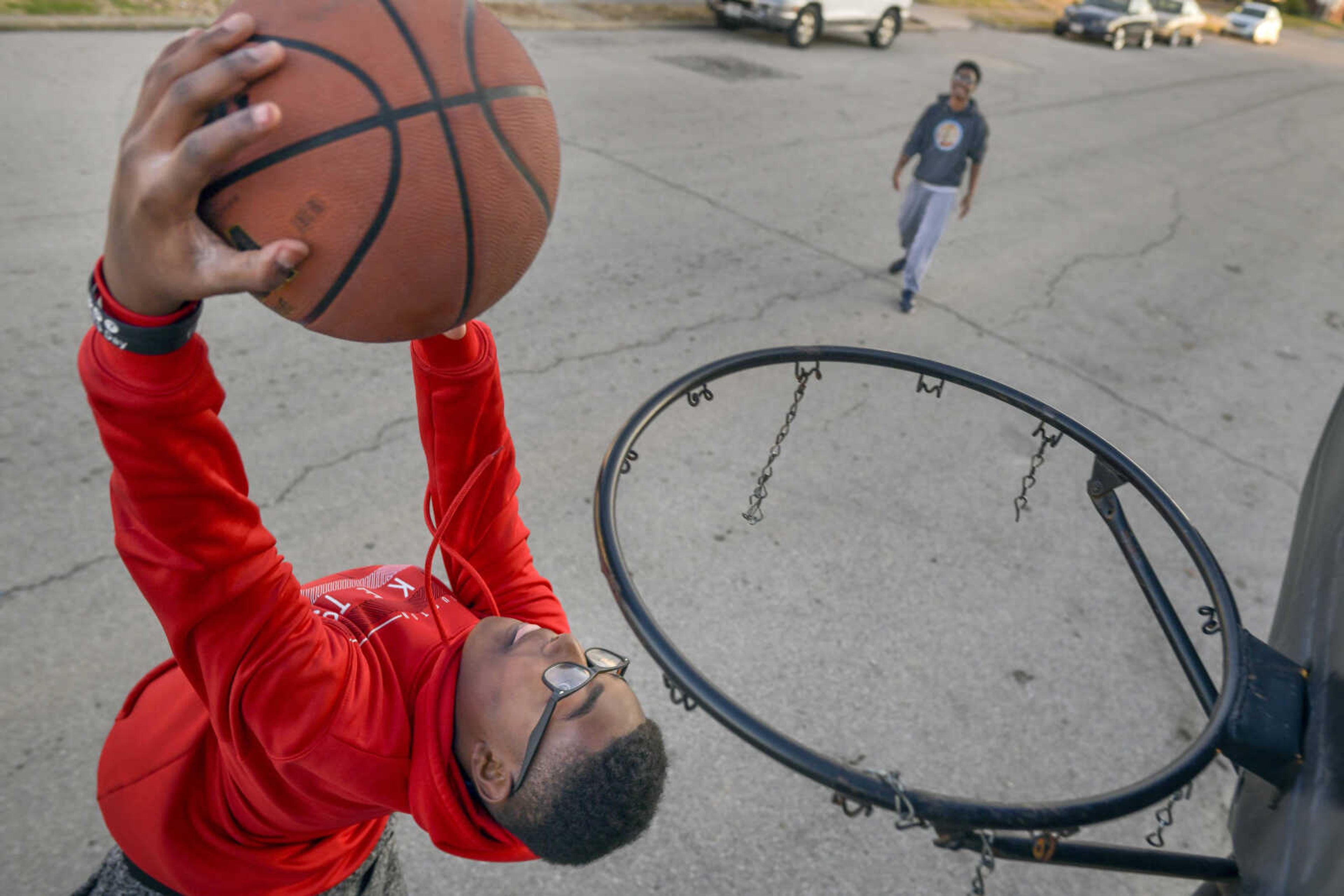 Jonathan Harris, 13, throws down a reverse-dunk as his older brother, Zacheriah, background, looks on while playing basketball Tuesday, Jan. 14, 2020, on South Ellis Street in Cape Girardeau.
"I had to teach myself [how to play basketball]," Zacheriah said. "And then I had to teach him (Jonathan.)"
"That's why I'm so good," Jonathan added. "Better than him!"