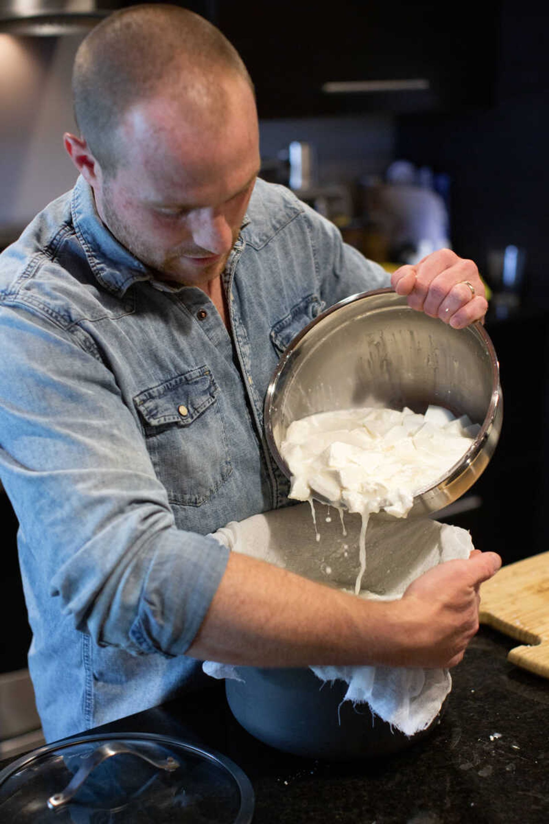 Trever Duncan separates the curd from the whey as he makes a batch of cheese. Trever says the cheese is just a bonus of raising goats.