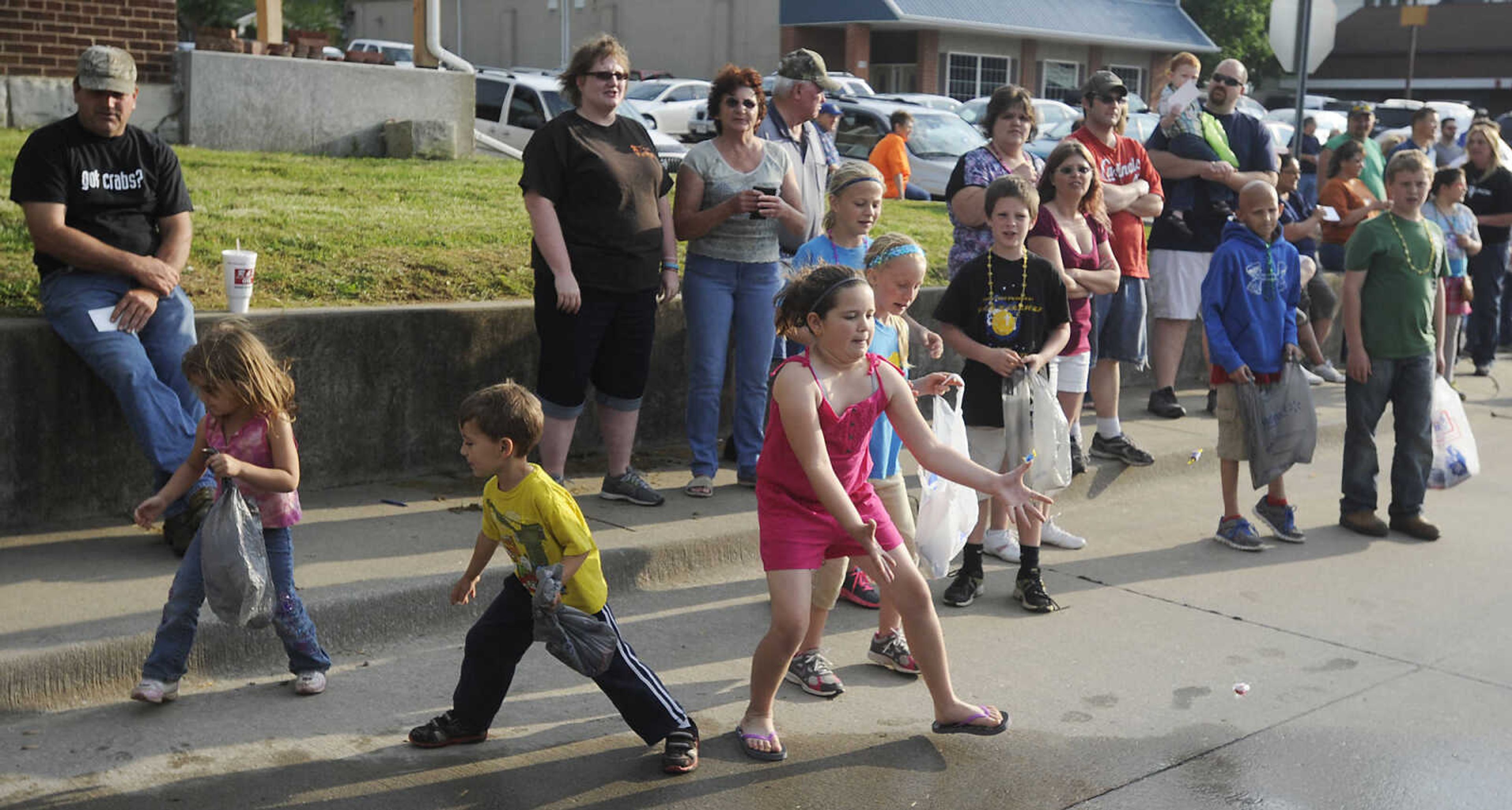 Children scramble for candy during the Perryville Mayfest Parade Friday, May 10, in Perryville, Mo. This year's Mayfest theme is Peace, Love, Perryville Mayfest.