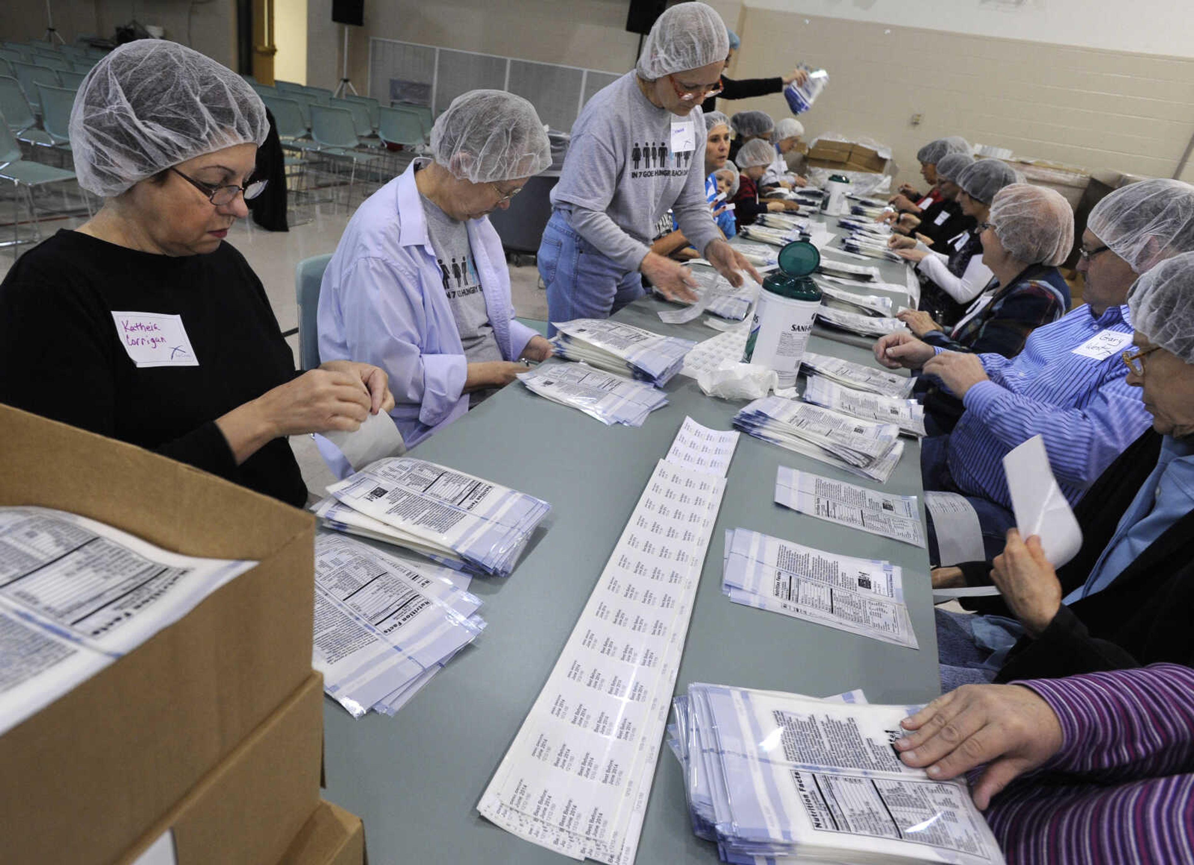 Volunteers attach "Best Before June 2014" labels to the MannaPack Rice bags.