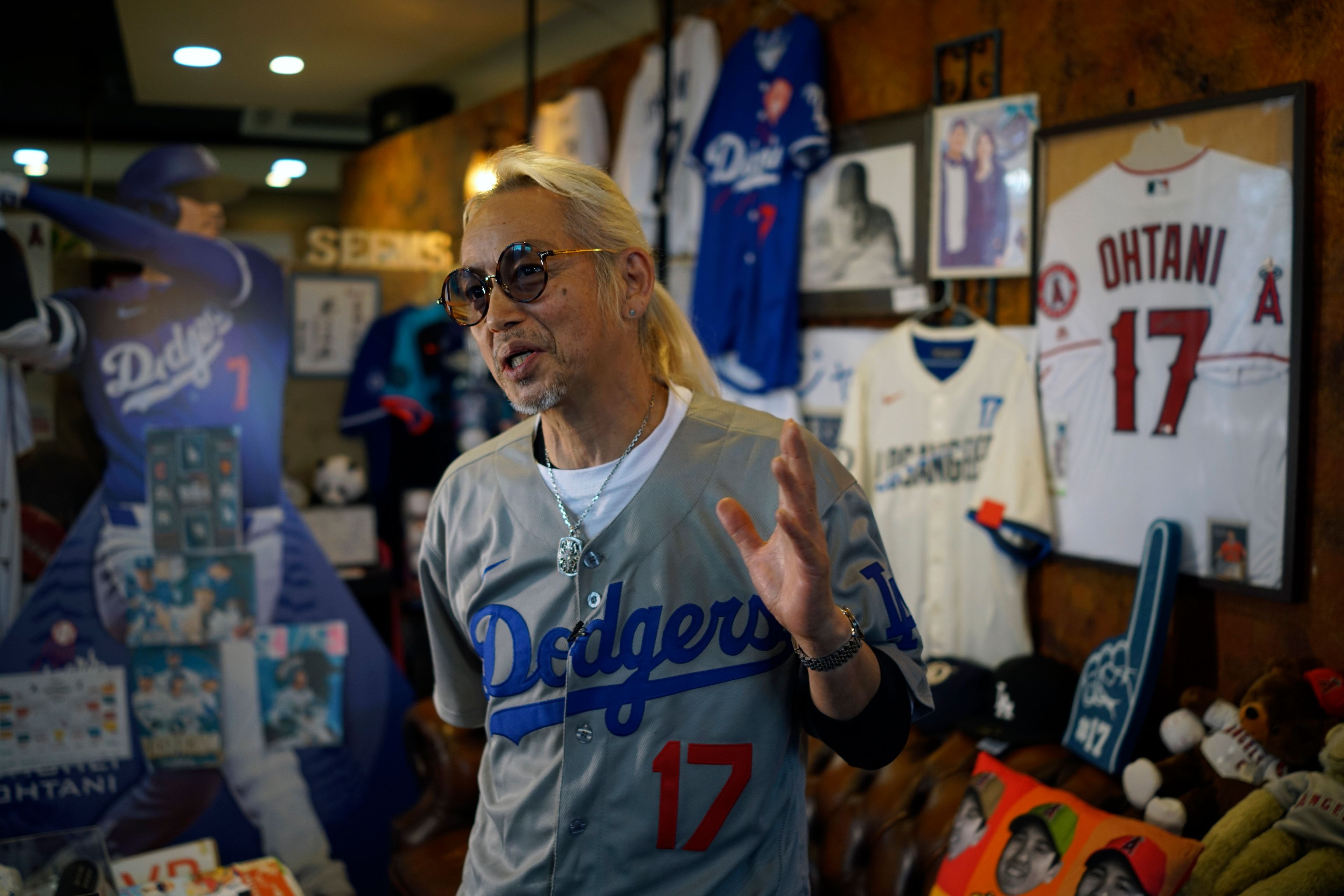 Hironobu Kanno, representative of a private fan club of Shohei Ohtani of the Los Angeles Dodgers, speaks surrounded by his collection goods of Ohtani at his beauty salon in Oshu, northeastern Japan, the hometown of Ohtani, Tuesday, Oct. 29, 2024. (AP Photo/Eugene Hoshiko)