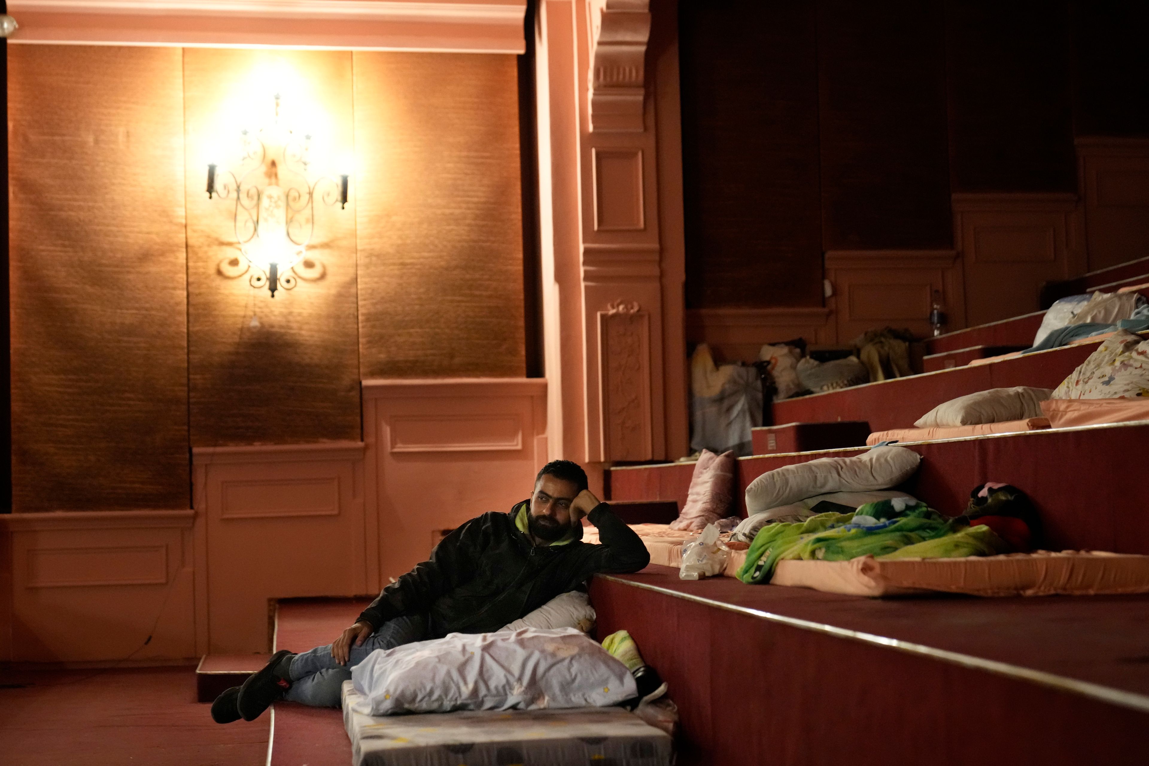 Adulkader Kurdi, who fled the ongoing Hezbollah-Israel war in south Lebanon, lies on a mattress inside one of Beirut's oldest and best known movie theatres, Le Colisee, in Beirut, Lebanon, Tuesday, Oct. 22, 2024. (AP Photo/Hussein Malla)