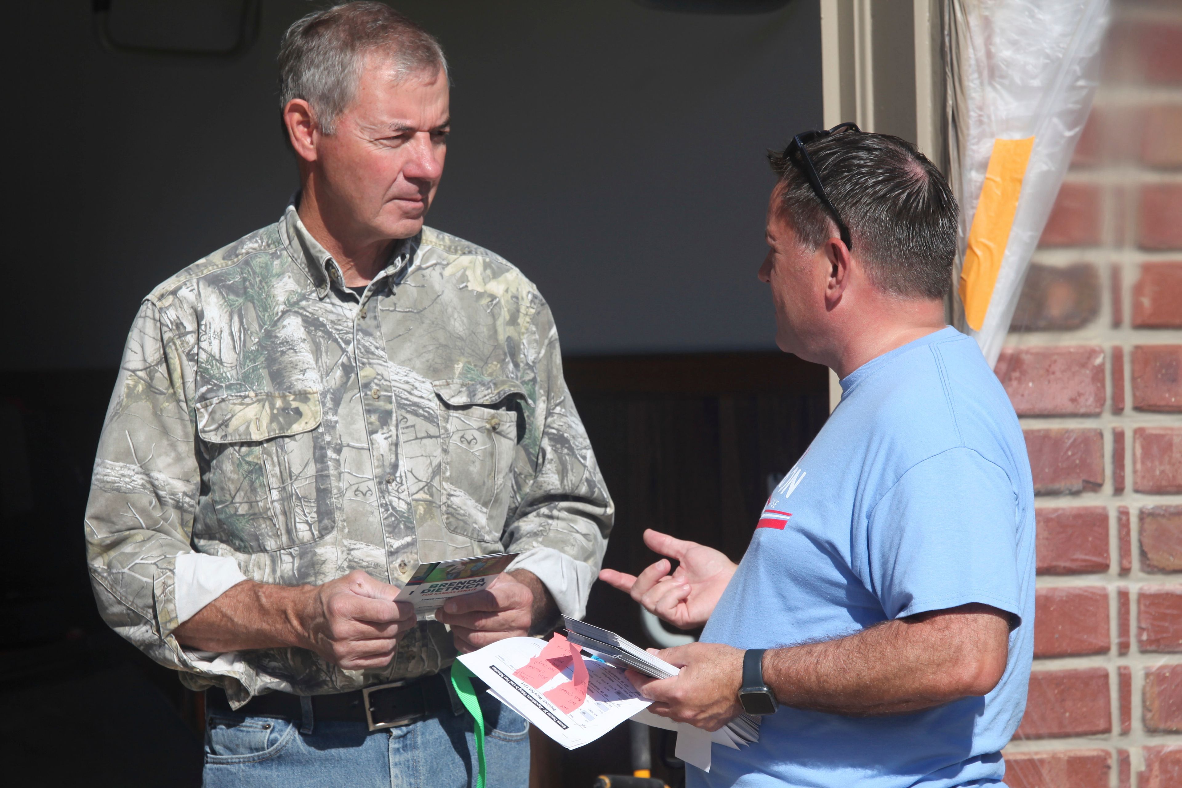 Bob Schmidt, right, a Republican voter, talks to state Rep. Jesse Borjon, left, R-Topeka, outside the garage of Schmidt’s home, Saturday, Oct. 5, 2024, in Topeka, Kansas. (AP Photo/John Hanna)