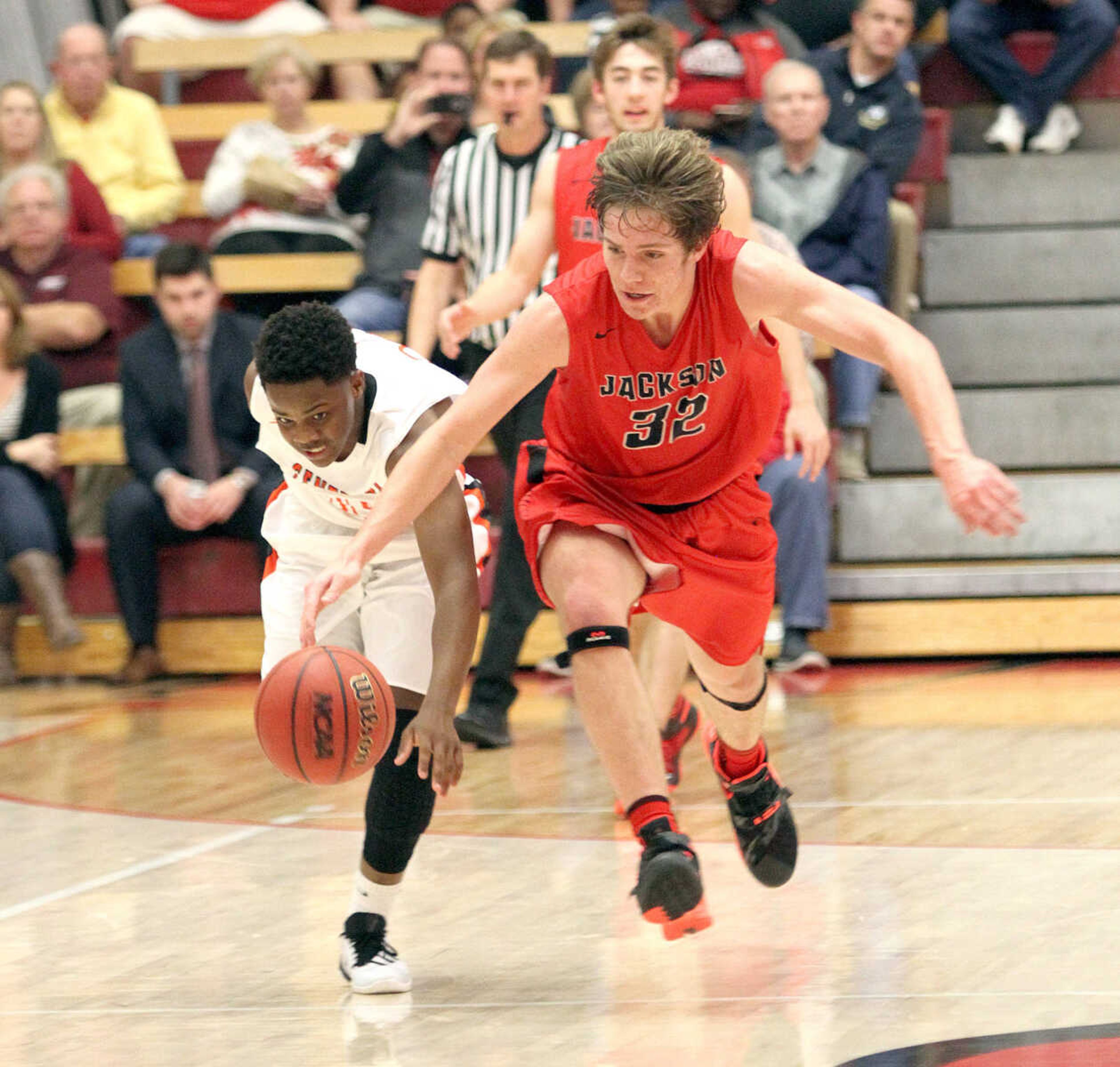 Jackson's Cameron Hester and Cape Central's Jawone Newell try to chase down a loose ball in the consolation finals of the SEMO Conference Tournament on Friday night at the Sikeston Field House. (David Jenkins/Standard Democrat)