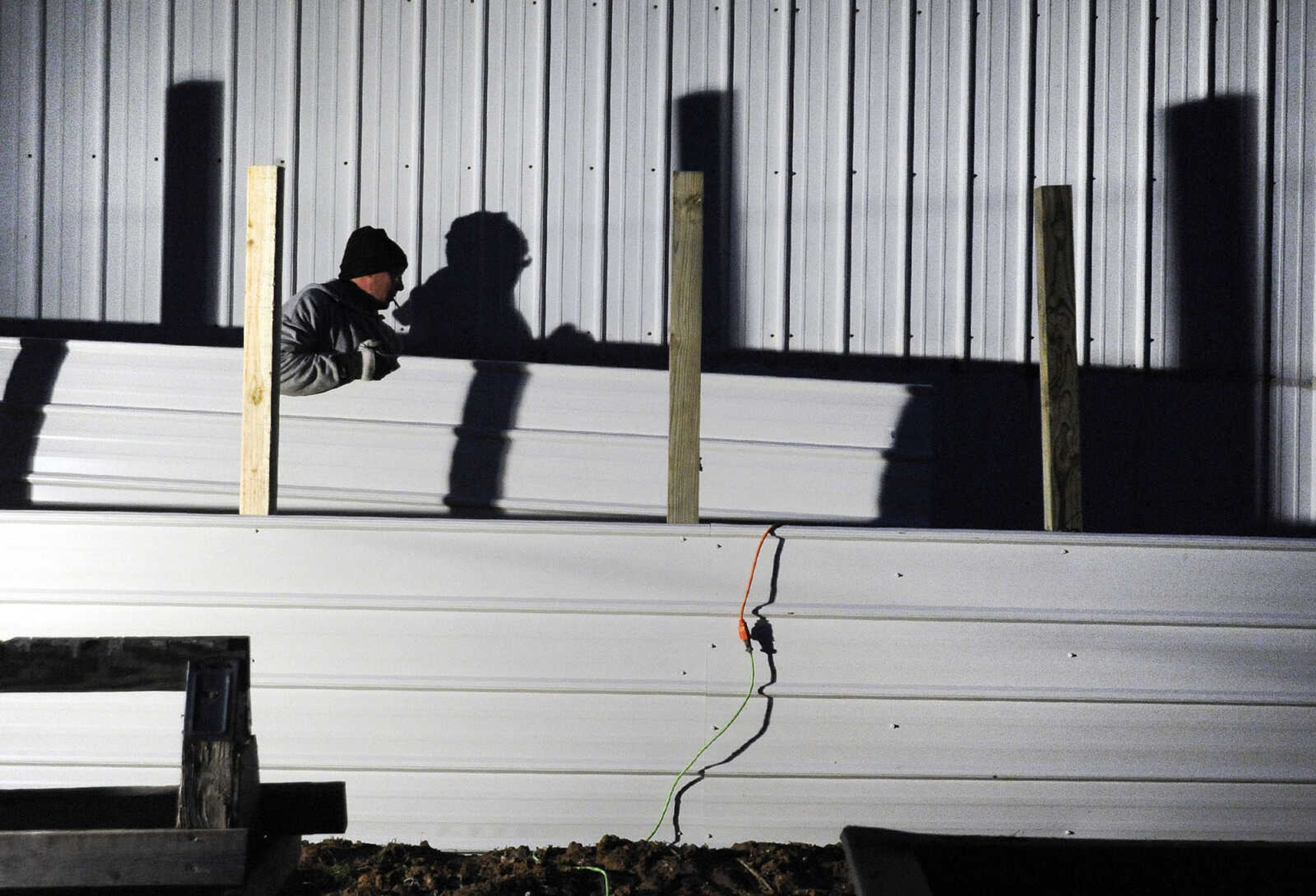 LAURA SIMON ~ lsimon@semissourian.com

Matt Butler works on a tin fence to surround a workshop near the Red Star Access in Cape Girardeau Tuesday evening, Dec. 29, 2015. Flooding from the Mississippi River is encroaching on the shop.