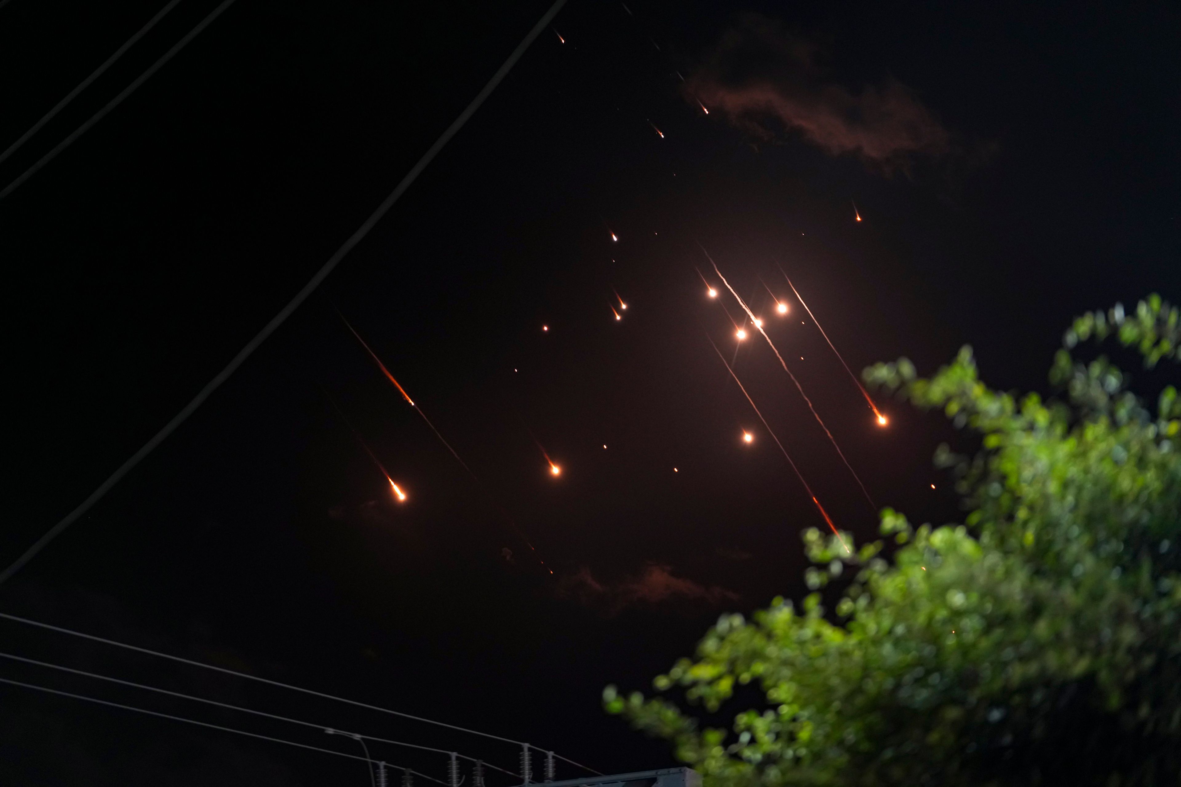 Missiles launched from Iran towards Israel streak across the night sky as seen from Deir al-Balah, Gaza Strip, Tuesday, Oct. 1, 2024. (AP Photo/Abdel Kareem Hana)