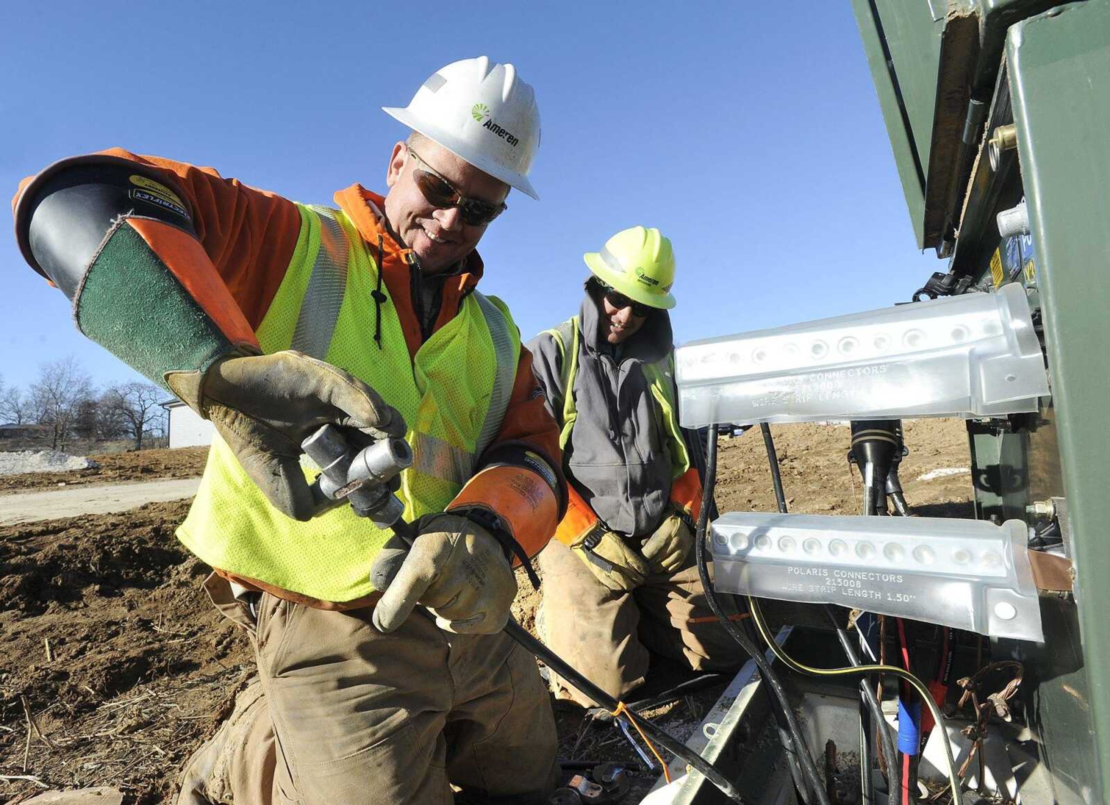 David McKay, left, line foreman for Ameren Missouri, connects electric cable to a transformer for new service in a subdivision as lineman Brett Burger looks on, Thursday, Dec. 29, in Jackson. McKay says he wears layers as well as coveralls over jeans on cold days at work.