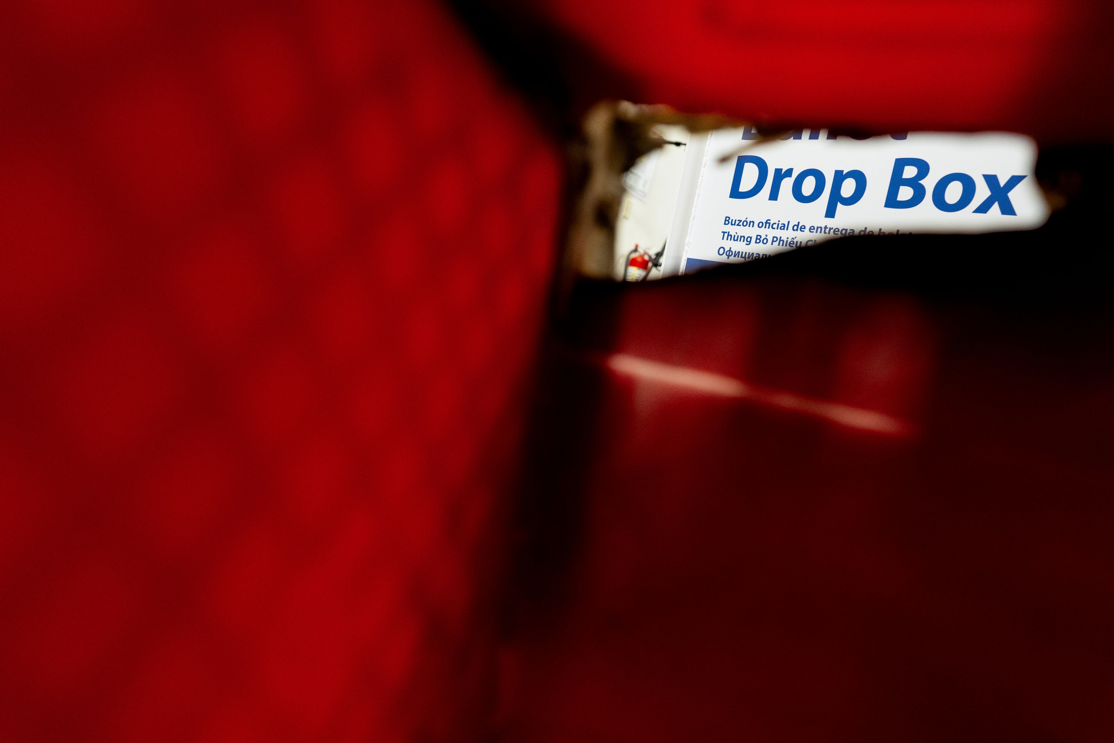 A fire-damaged ballot drop box bin is seen next to the drop box during a news conference at the Multnomah County Elections Division office on Monday, Oct. 28, 2024, in Portland, Ore. (AP Photo/Jenny Kane)