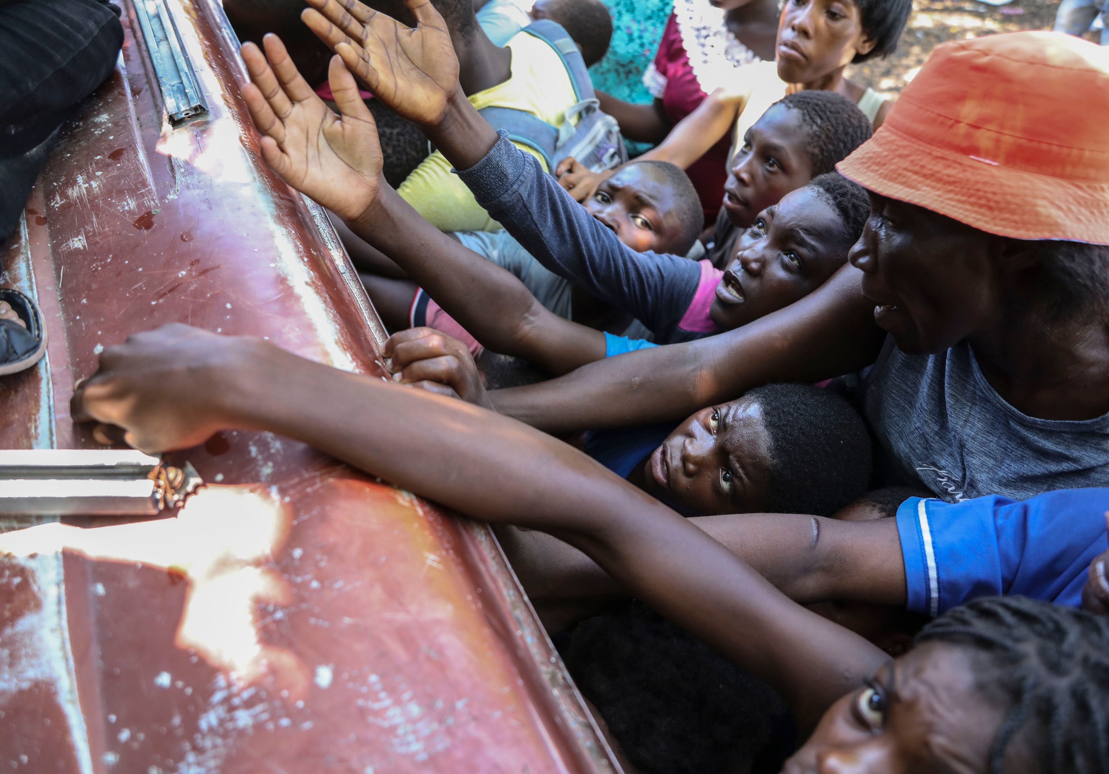 People displaced by armed attacks receive food from a nongovernmental organization in Saint-Marc, Haiti, Sunday, Oct. 6, 2024. (AP Photo/Odelyn Joseph)