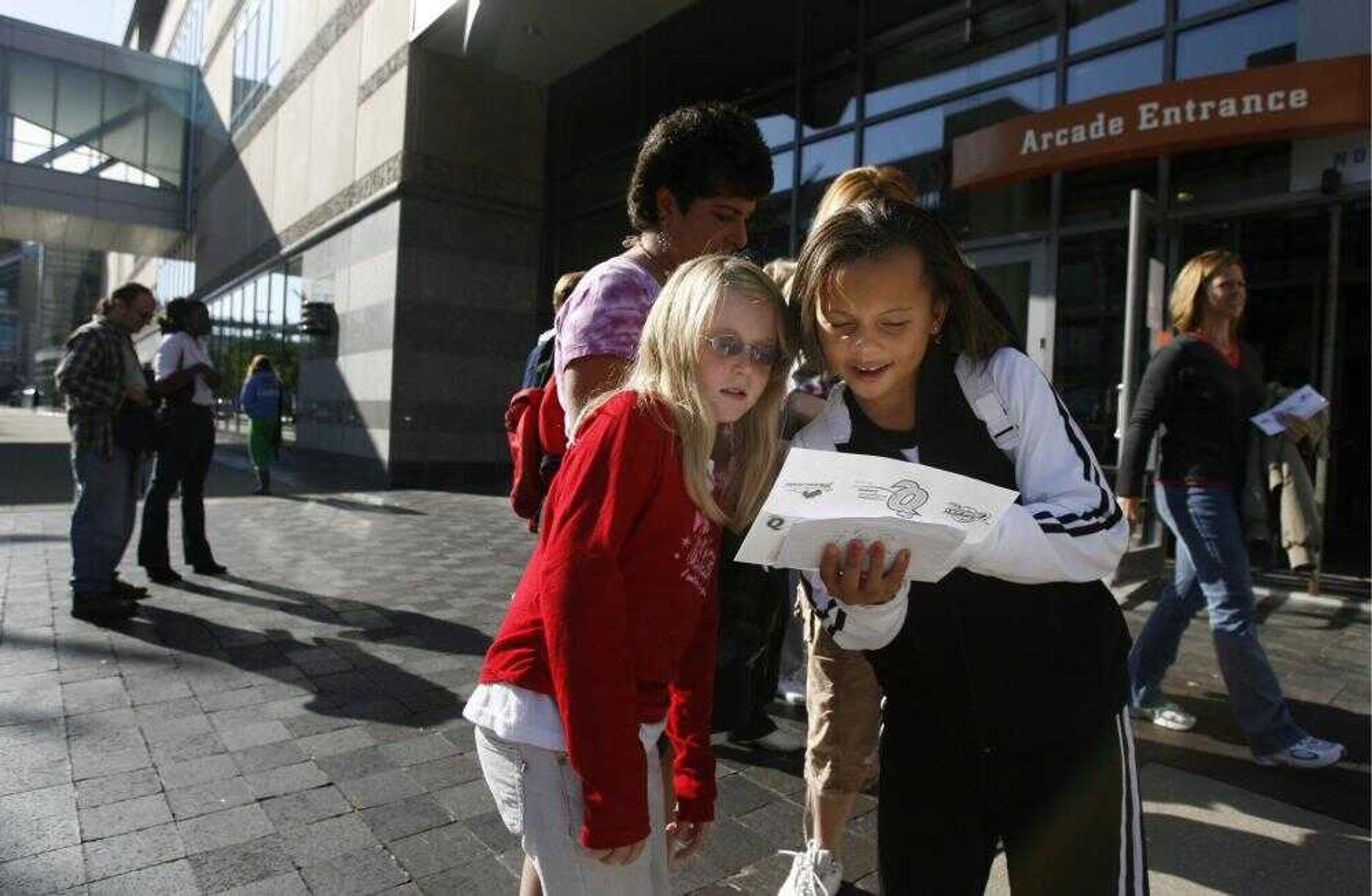 Paige Sebelin, 9, left, and Kayla Callans, 9, of Parma, Ohio, looked over their newly purchased tickets for "Hannah Montana" Sunday outside Quicken Loans Arena in Cleveland. The hottest concert ticket of the year is to 14-year-old Miley Cyrus' 54-date national tour as Hannah Montana, star of a Disney Channel show for kids. (TRACY BOULIAN ~ The Plain Dealer)