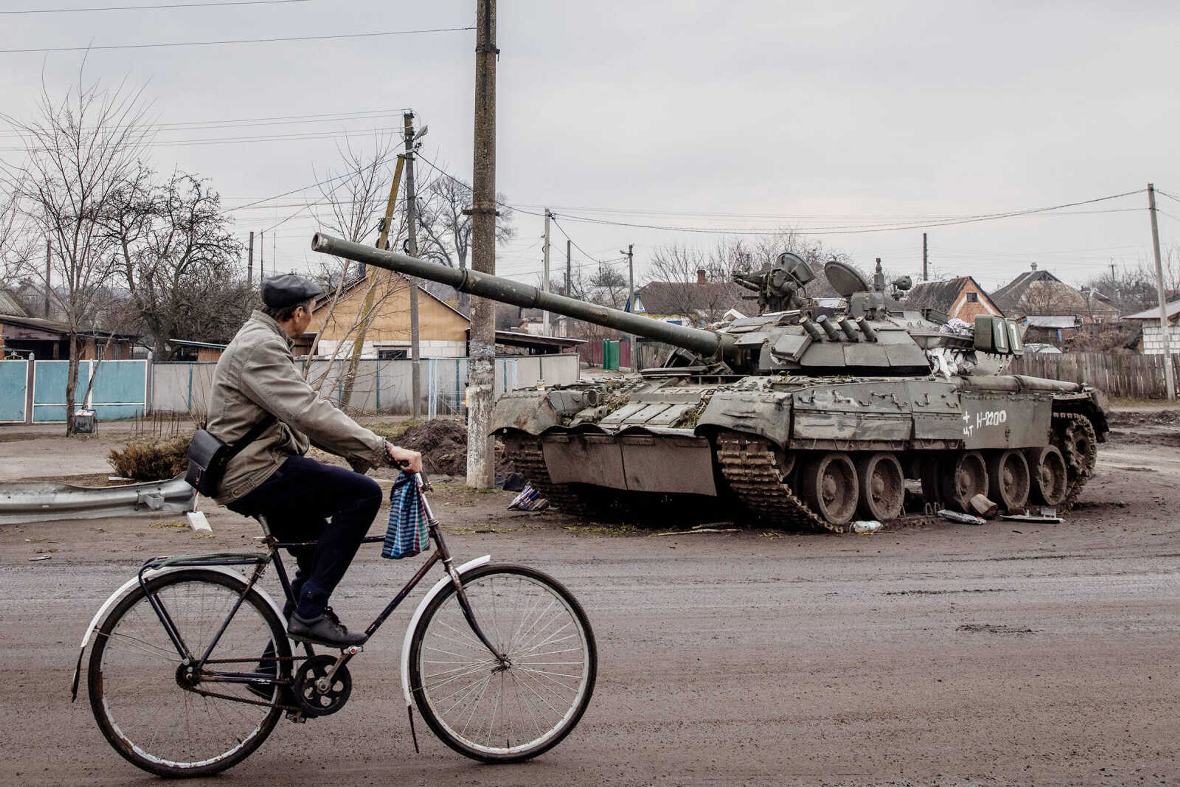 A man rides his bike past a destroyed Russian tank on Wednesday, March 30, 2022, in Trostyanets, Ukraine. Ukrainian forces announced this week that they had retaken Trostyanets, a northeastern town  that has seen fierce fighting and was occupied by Russians for weeks, from Russian control. 