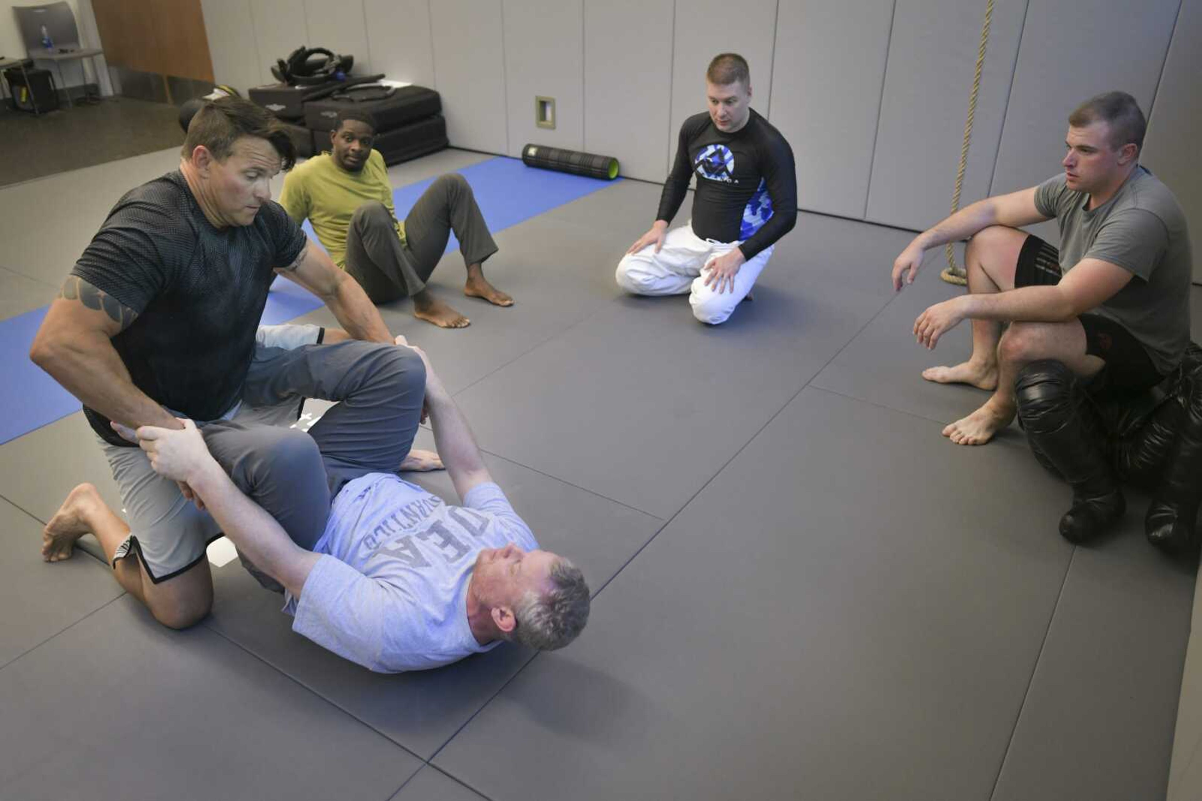 Clockwise from bottom left, Gracie Jiu-Jitsu of Southeast Missouri professor Brian Imholz demonstrates a self-defense technique as Cape Girardeau police Sgt. Joey Hann acts as an attacker while Gracie Jiu-Jitsu student Cantrell Andrews, police patrolmen Kris Spala and Jacob Monteith watch Wednesday at the Cape Girardeau Police Department in Cape Girardeau.