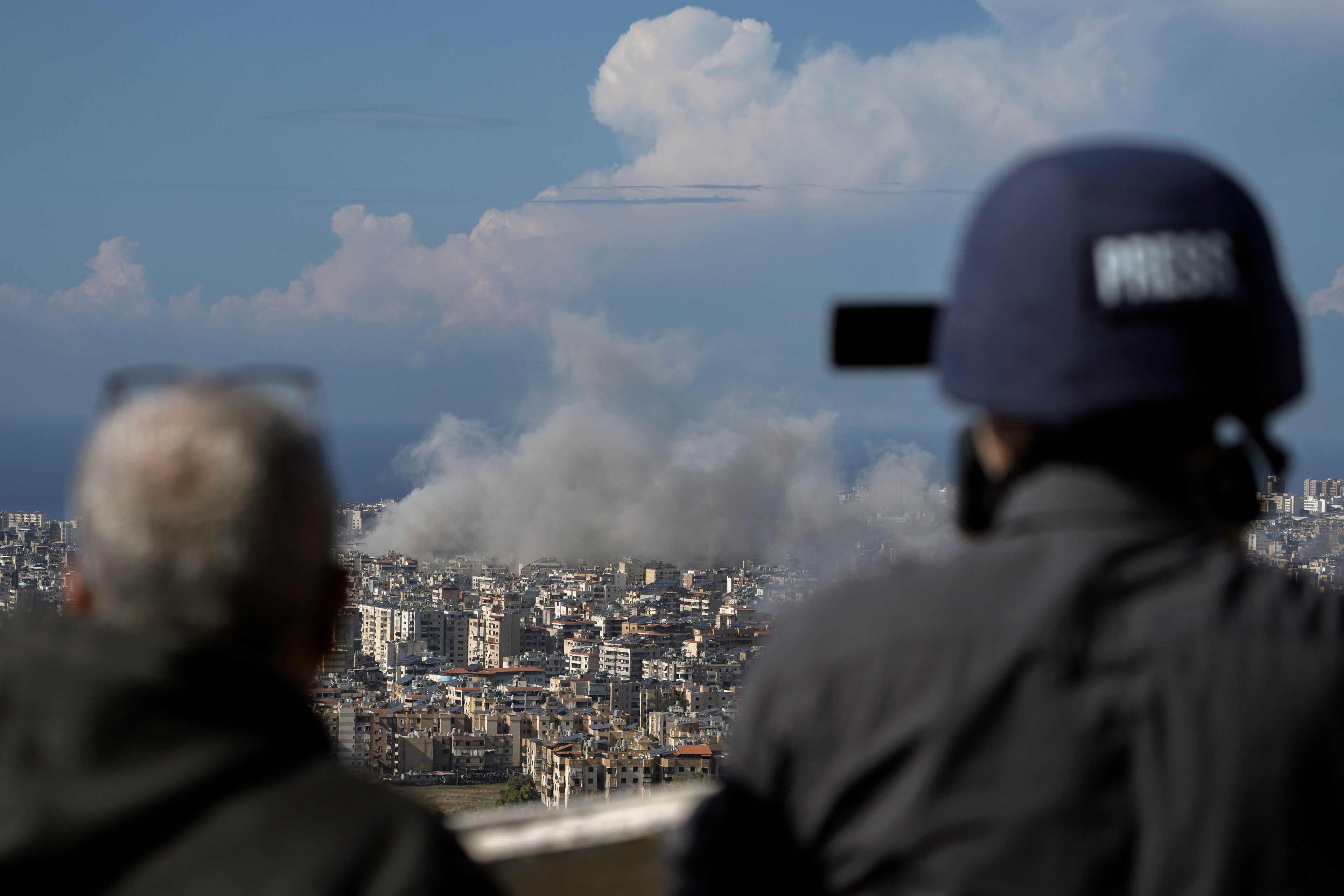 Journalists document as smoke rises after an Israeli airstrike on Dahiyeh, in the southern suburb of Beirut, Lebanon, Tuesday, Nov. 12, 2024. (AP Photo/Bilal Hussein)