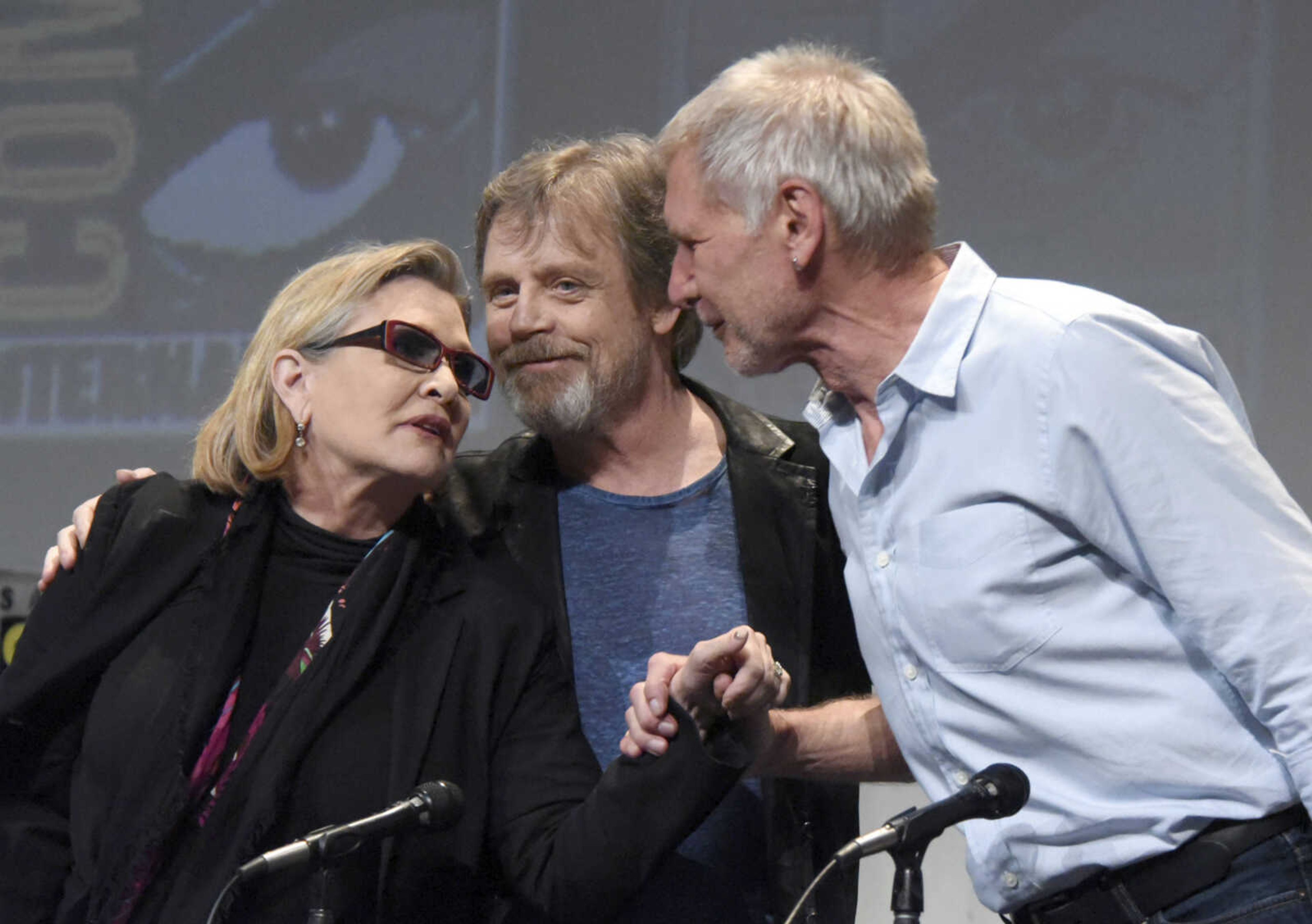 From left, Carrie Fisher, Mark Hamill and Harrison Ford attend a panel at Comic-Con International on July 10, 2015, in San Diego. Fisher died Tuesday at the age of 60.