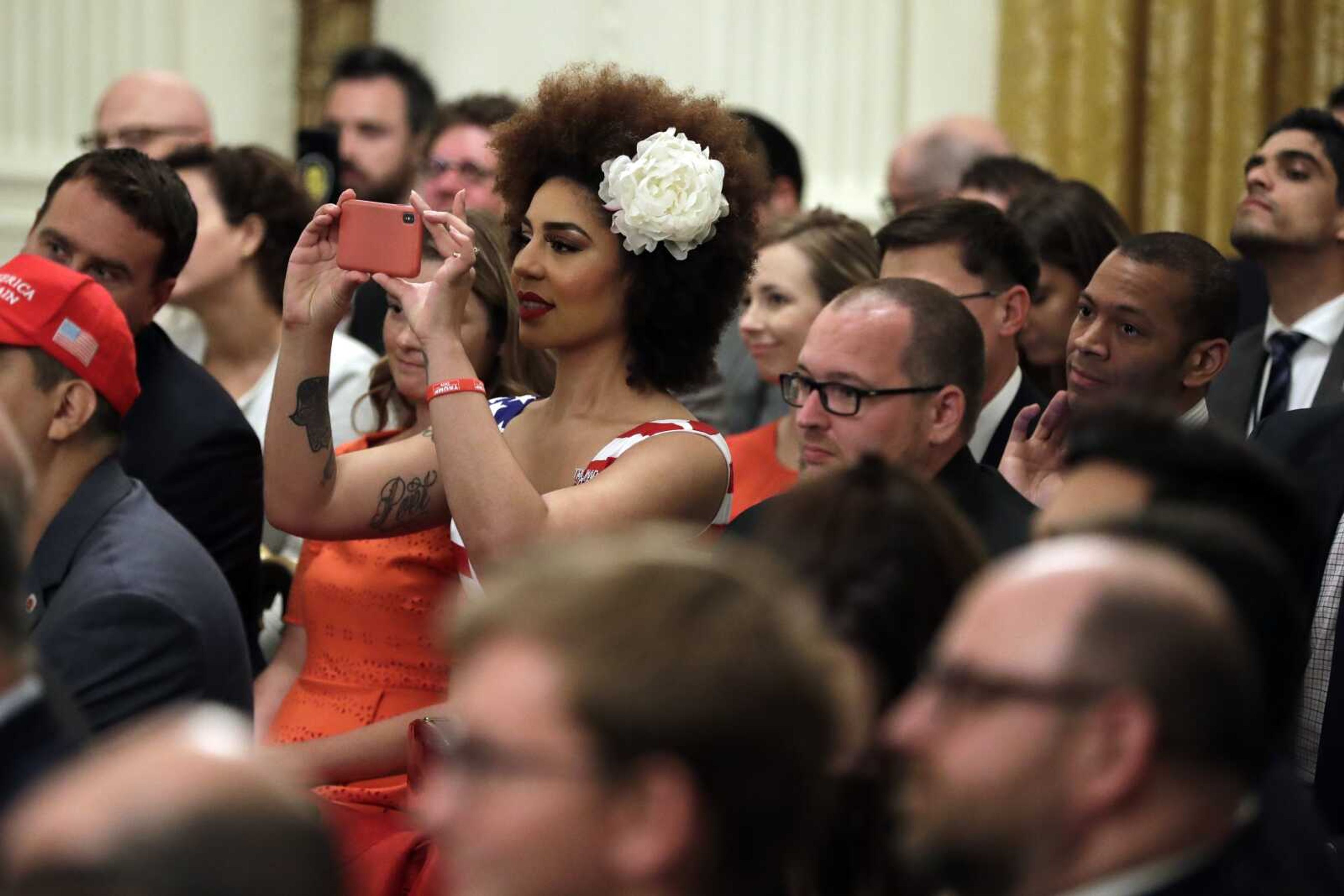 Invited guests take photos Thursday as President Donald Trump speaks during the Presidential Social Media Summit in the East Room of the White House in Washington.