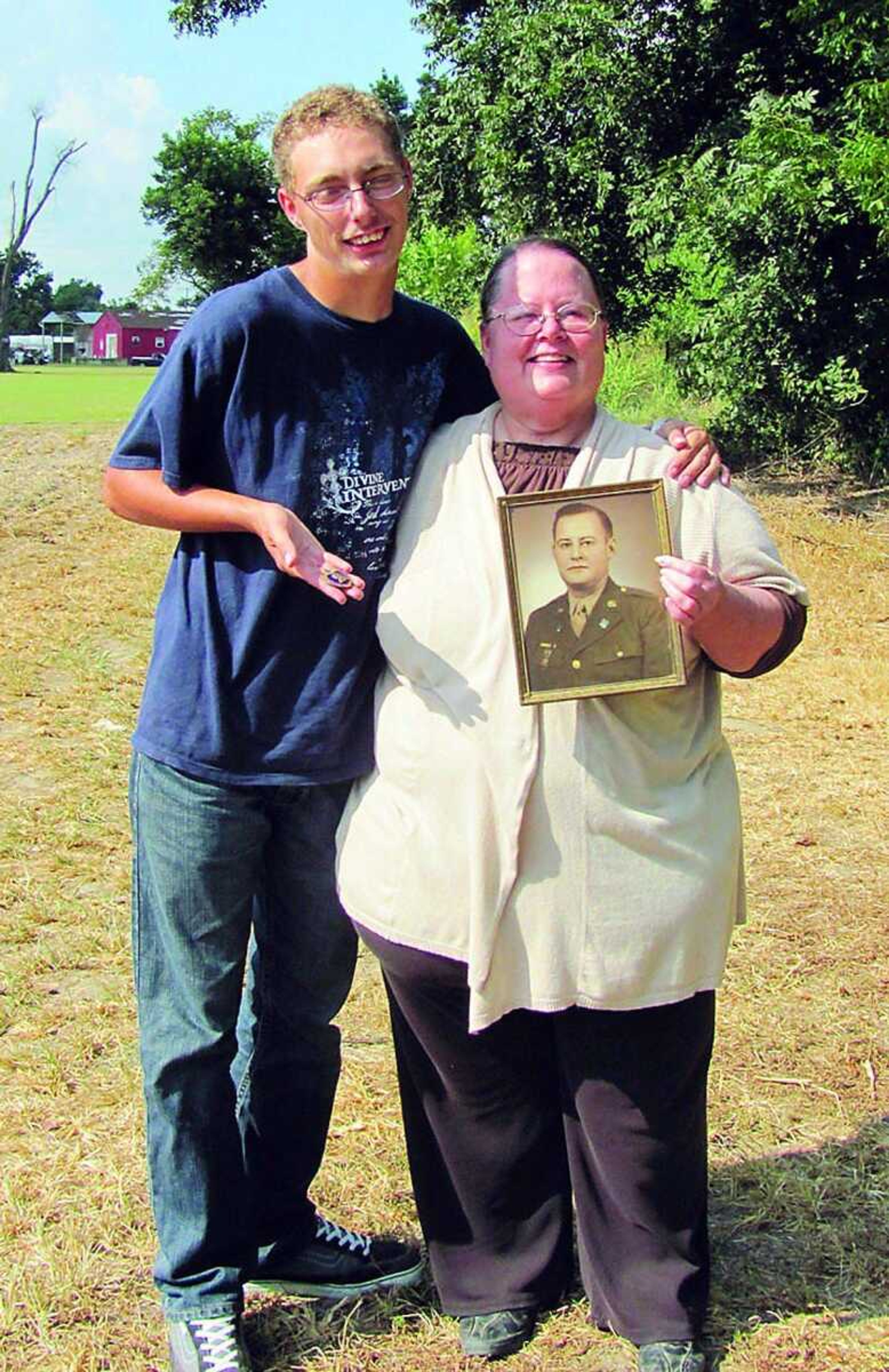 Pictured on the left is Chris Martin, holding the Purple Heart medal of Homer J. Moore and on the right is Sherry Drury, Paragould, Ark., daughter of Moore. She is holding her father's picture. (Lecia Forester ~ Daily Dunklin Democrat)