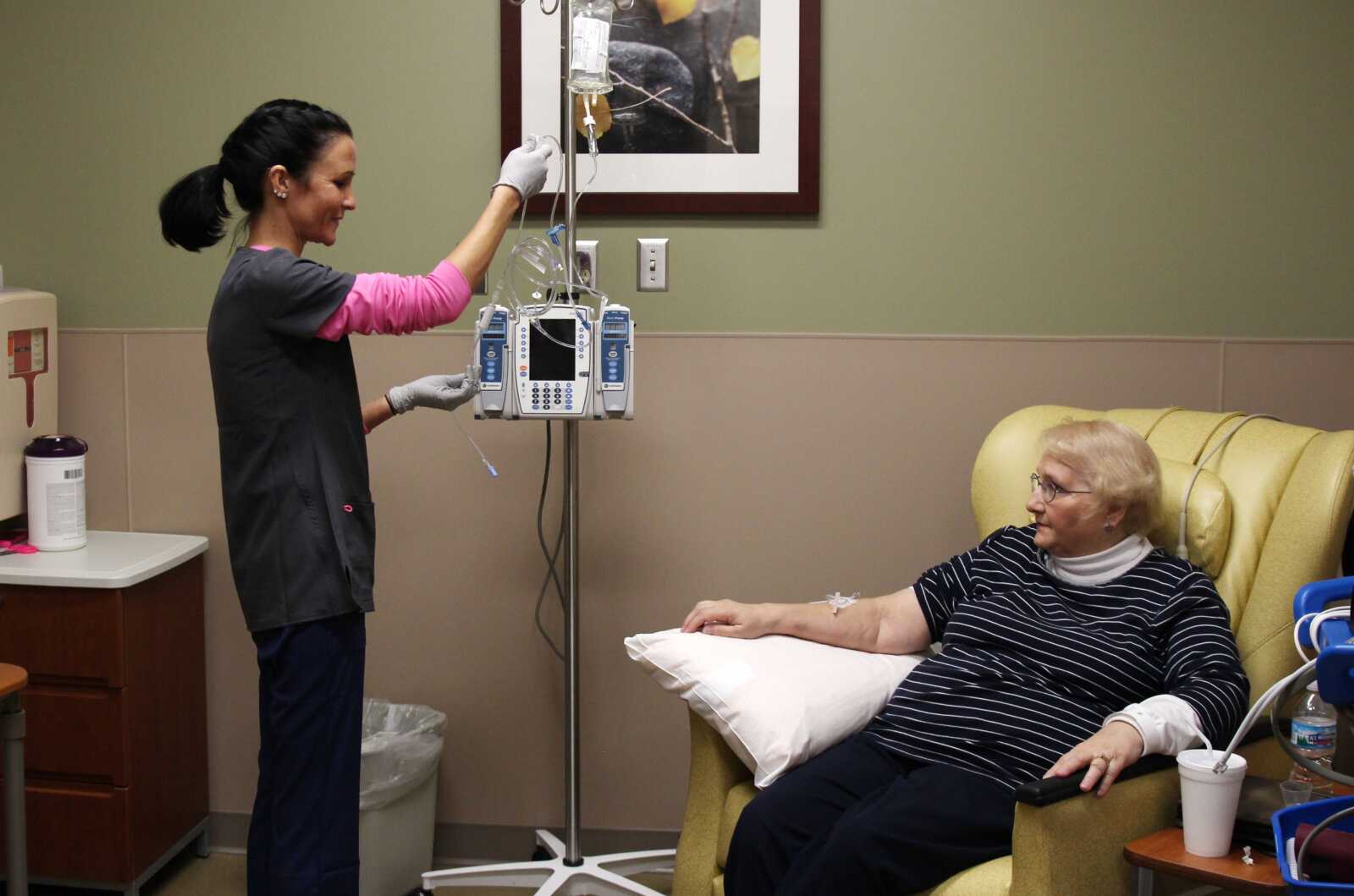 Nurse Nicole Krahn, left, gets rheumatoid arthritis medication ready for semi-retired nurse Lynn Bartos at Froedtert & the Medical College of Wisconsin in Wauwatosa, Wisconsin. The two have switched roles from more than 25 years ago, when Bartos cared for Krahn as a toddler. (Carrie Antlfinger ~ Associated Press)