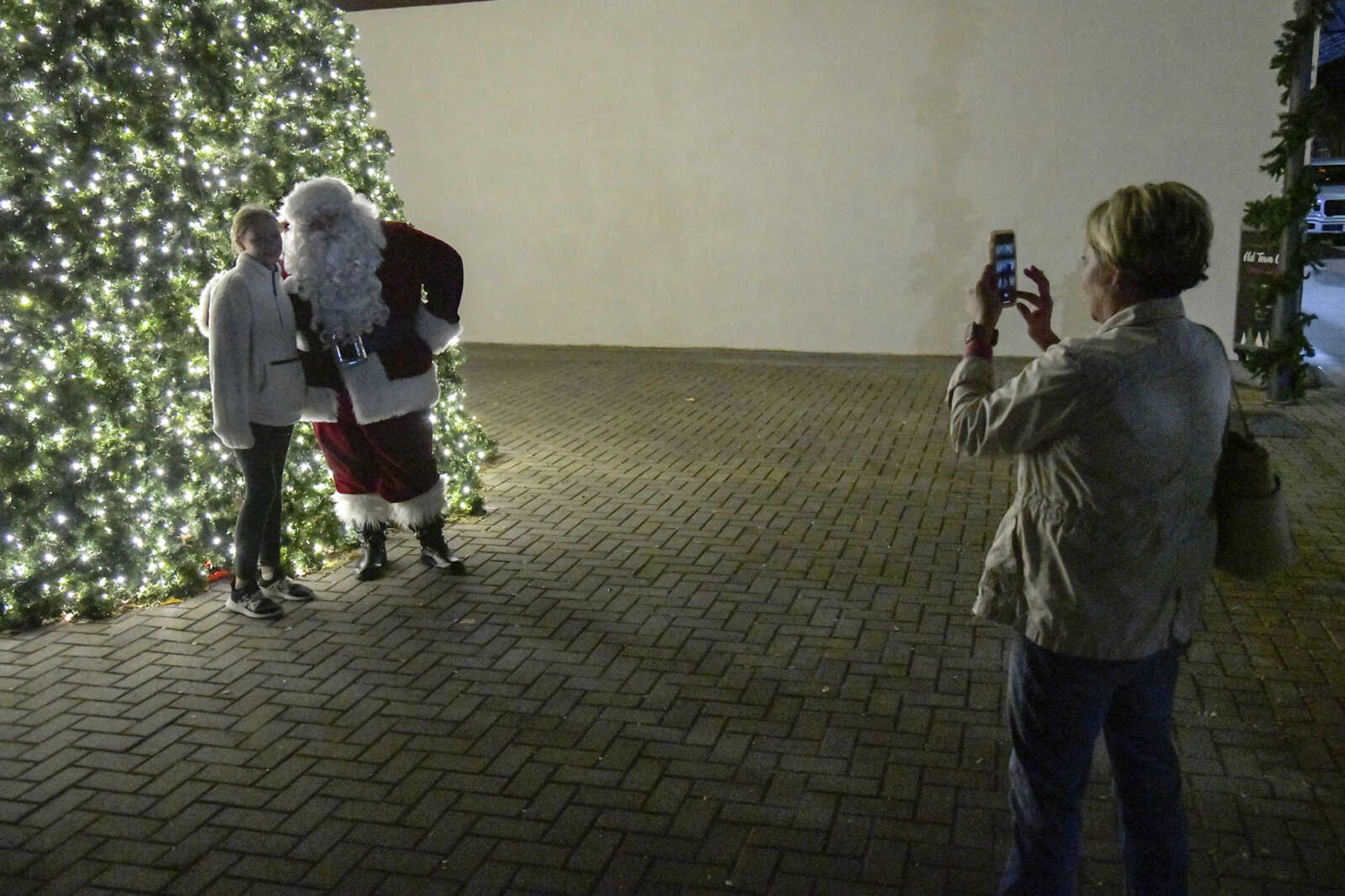 Alex Johnson, 11, poses for a picture with Santa Claus during the Annual Downtown Holiday Open House on Friday in Cape Girardeau.