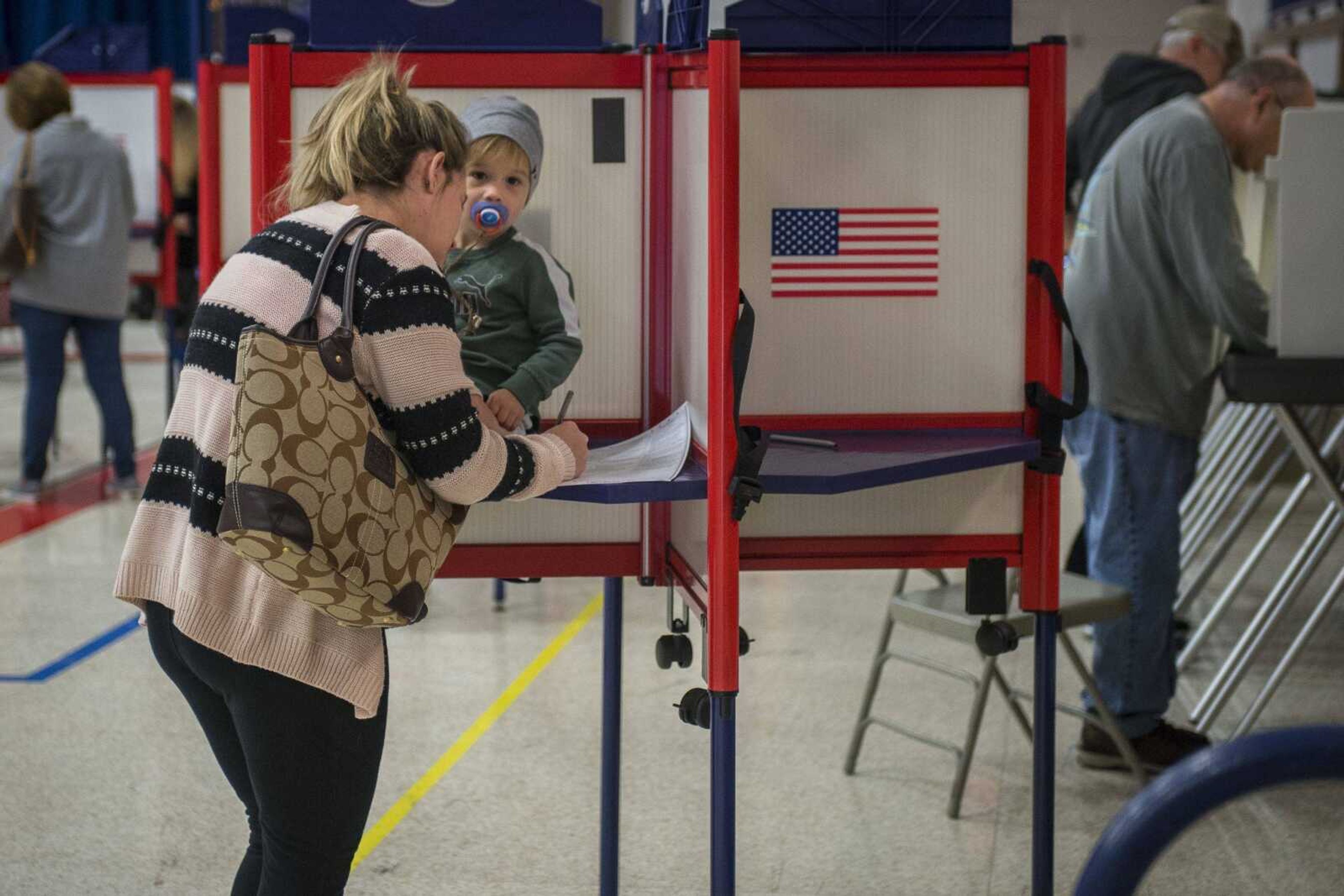 Tasha Valleroy completes her ballot as her 2-year-old son, Hayden Felter, sits in the voting booth Tuesday at the Arena Building in Cape Girardeau.