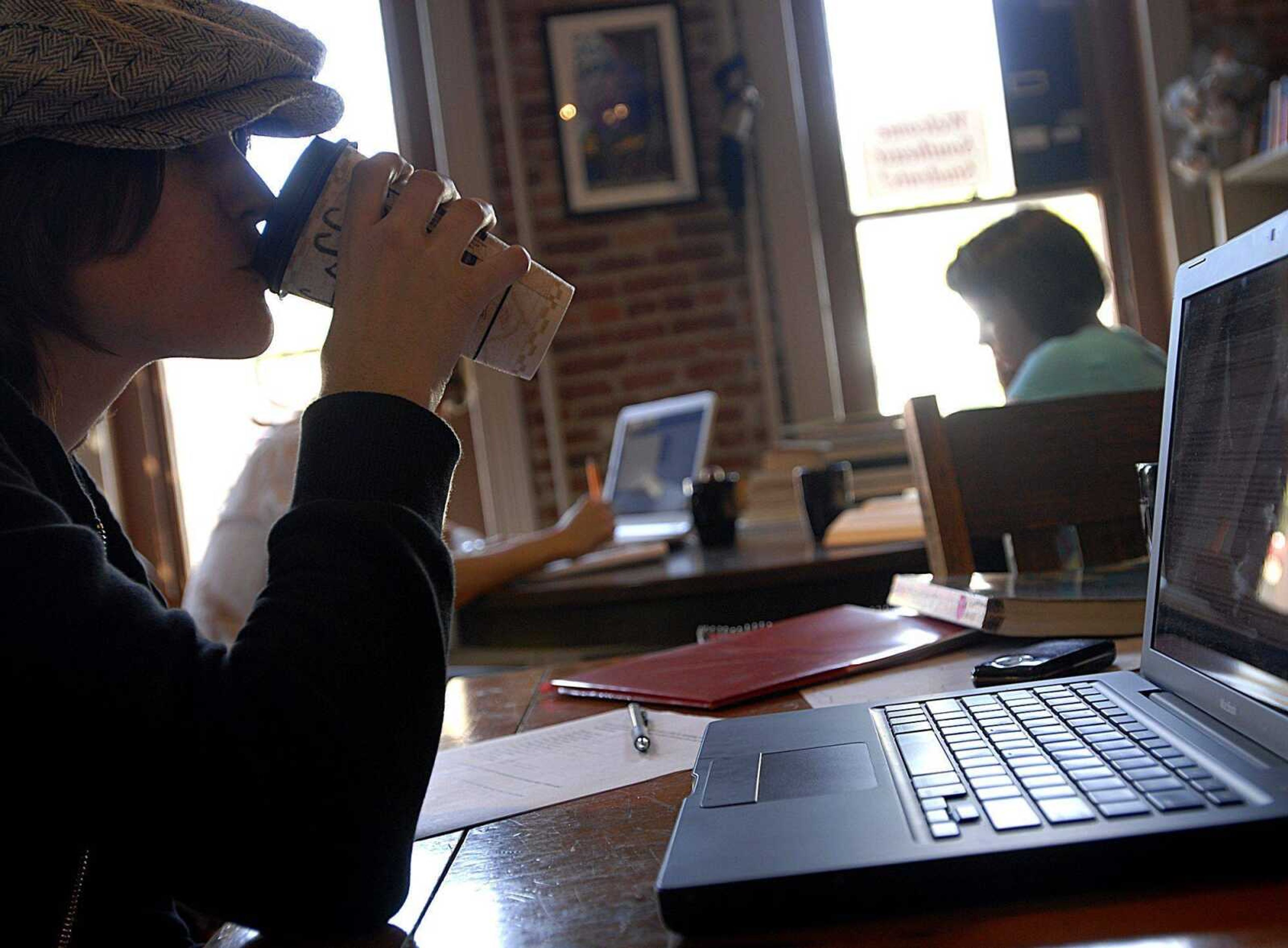 AARON EISENHAUER ~ aeisenhauer@semissourian.com
Elizabeth Coffey takes a sip from her drink as she works on homework, taking advantage of the wireless internet access at Broadway Books and Roasting on Friday.