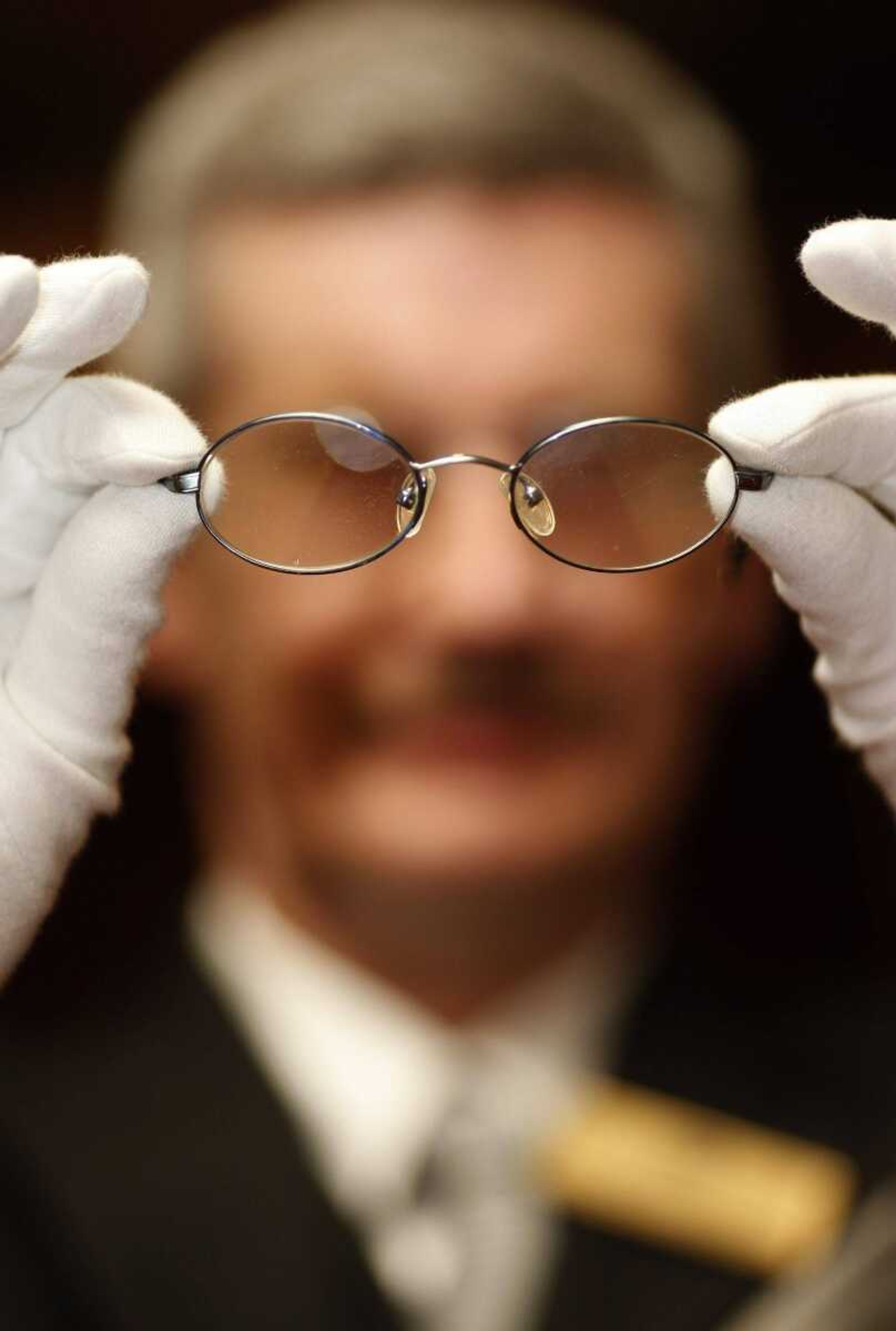 A pair of glasses donated by "Harry Potter" star Daniel Radcliffe was held Thursday by Stephen Gibbs, assistant head of Liverpool's Lord Mayor's Office, before an exhibition to mark National Holocaust Memorial Day in Liverpool, England. (JON SUPER ~ Associated Press)