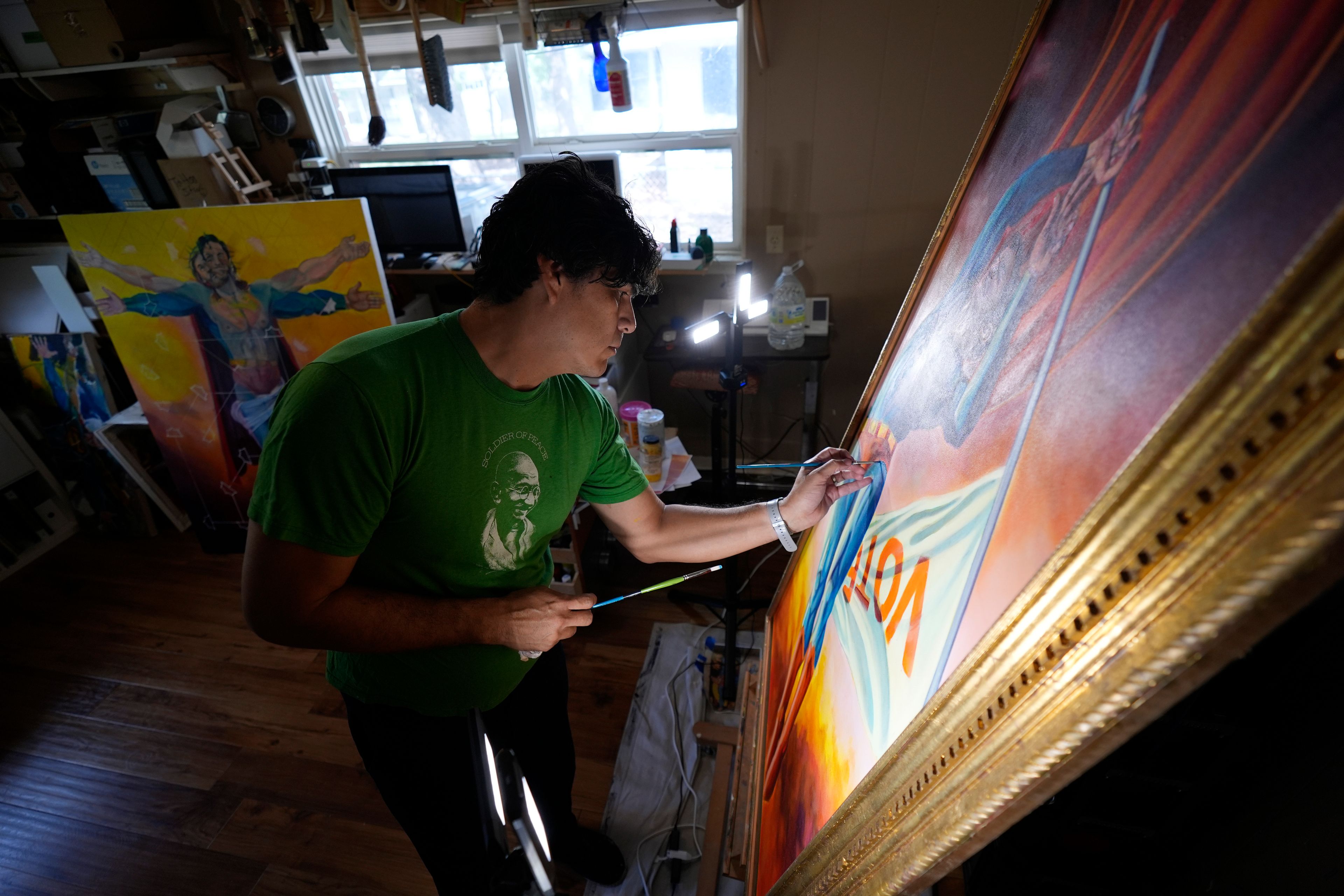 Artist David Alcantar works on an art piece for his "Superman Project" that in part encourages people to exercise their right to vote in San Antonio, Thursday, Sept. 19, 2024. (AP Photo/Eric Gay)